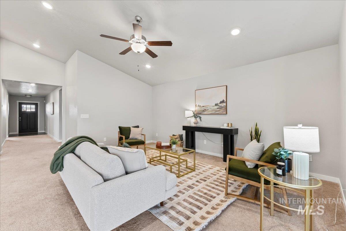 Living room with light colored carpet, lofted ceiling, recessed lighting, and a ceiling fan