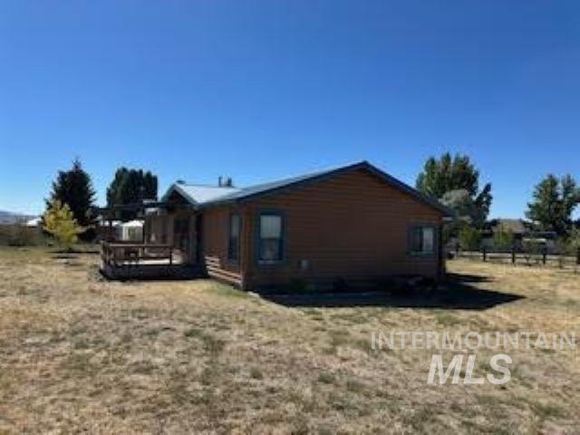 View of side of home featuring a deck and a yard