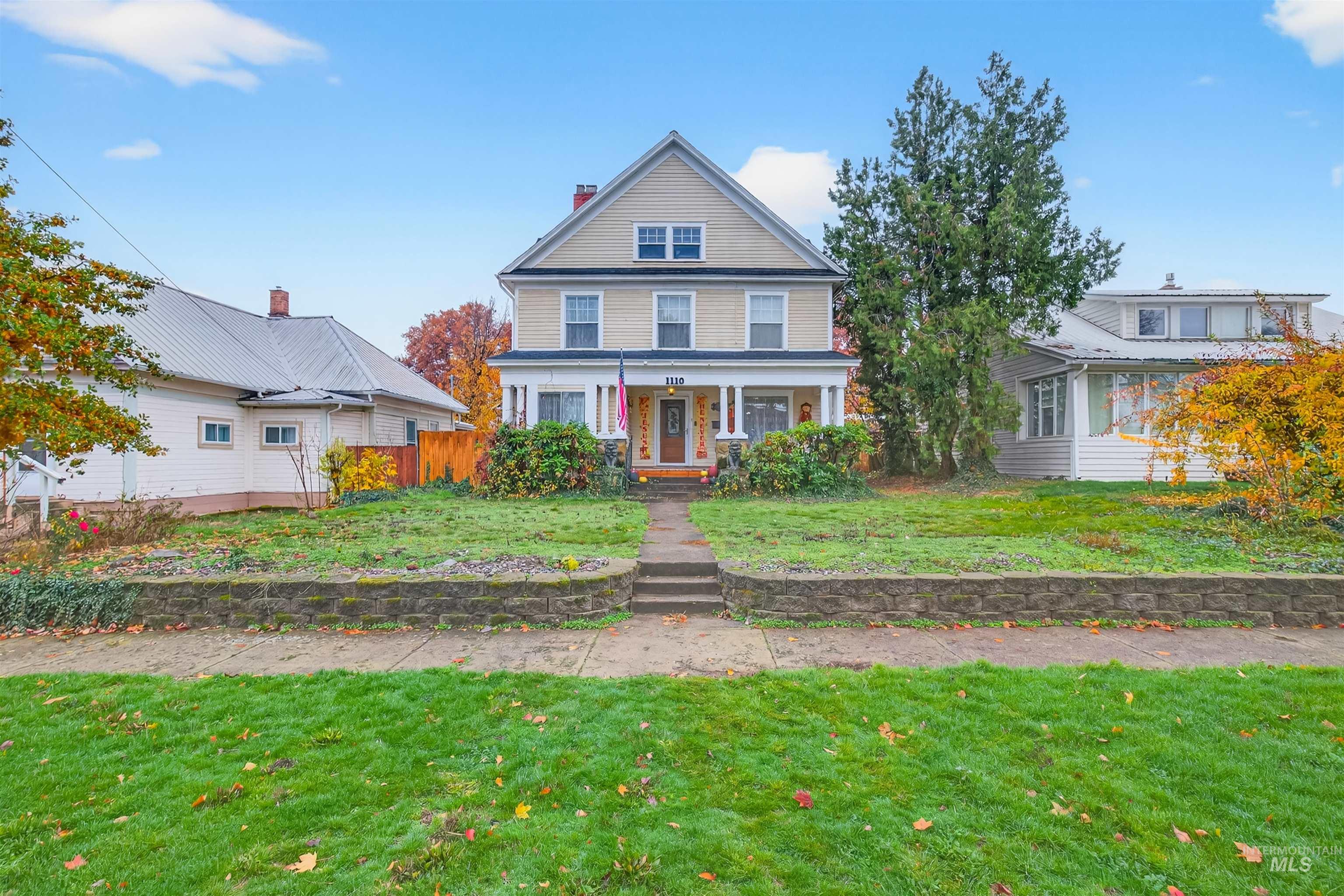 View of front of property featuring a front yard, a porch, and a chimney