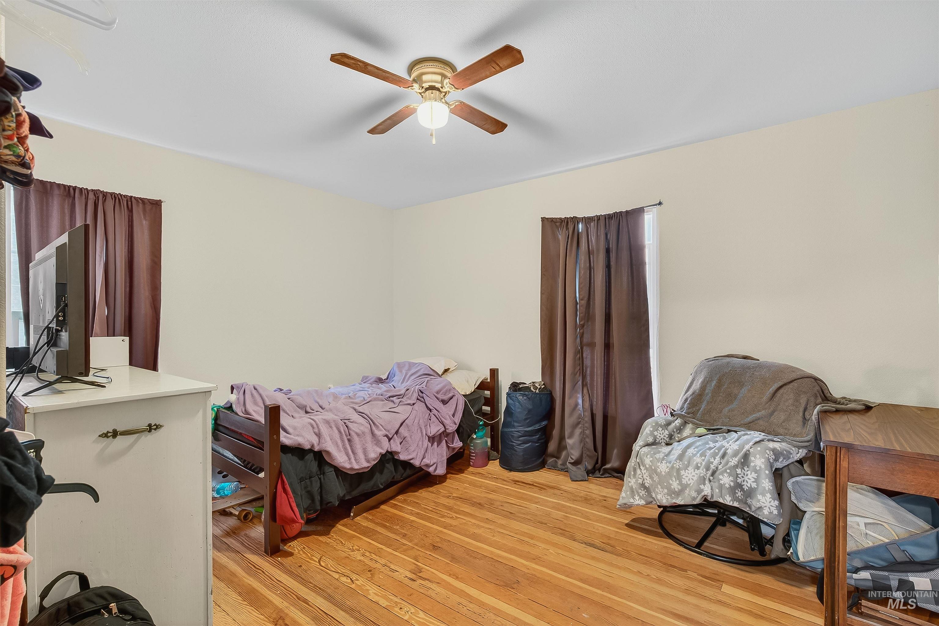 Bedroom with light wood-style flooring and a ceiling fan
