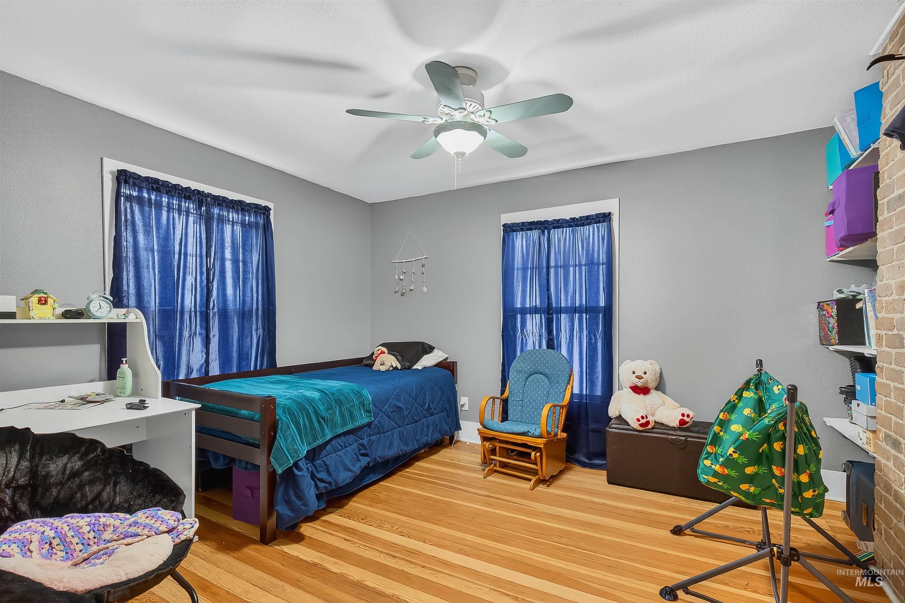 Bedroom with wood finished floors and a ceiling fan