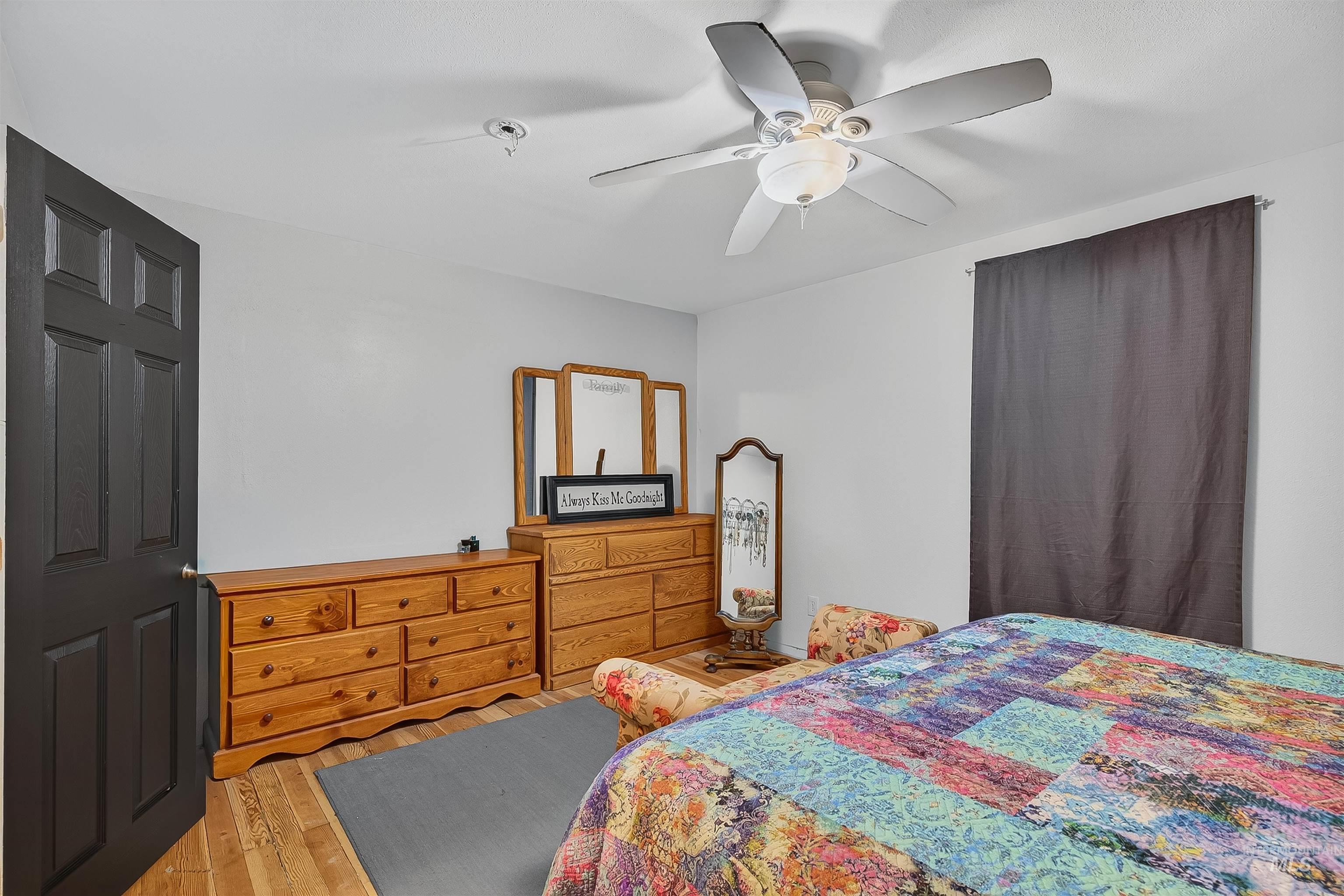 Bedroom with hardwood / wood-style floors and ceiling fan