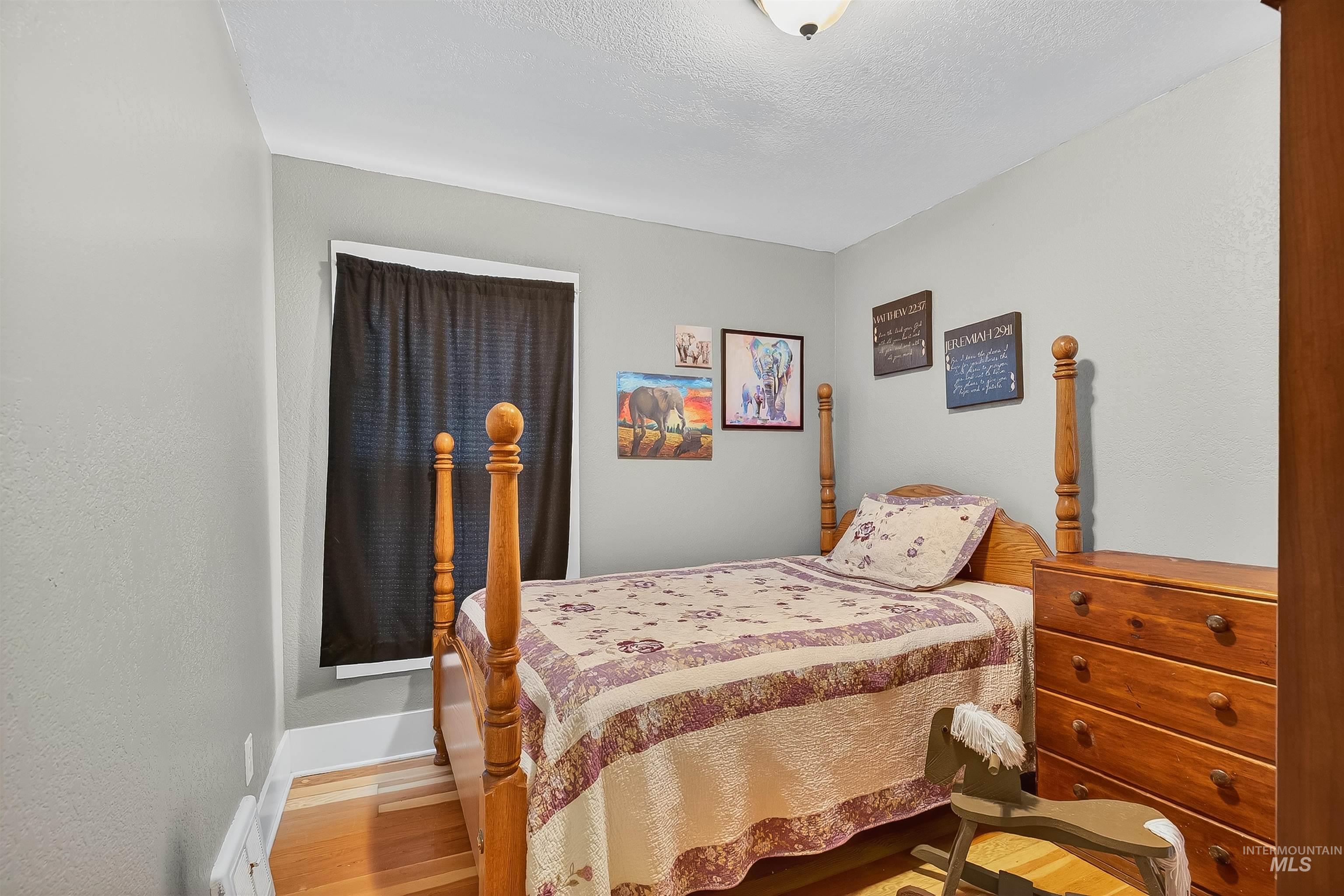 Bedroom with light wood-style flooring and a textured ceiling