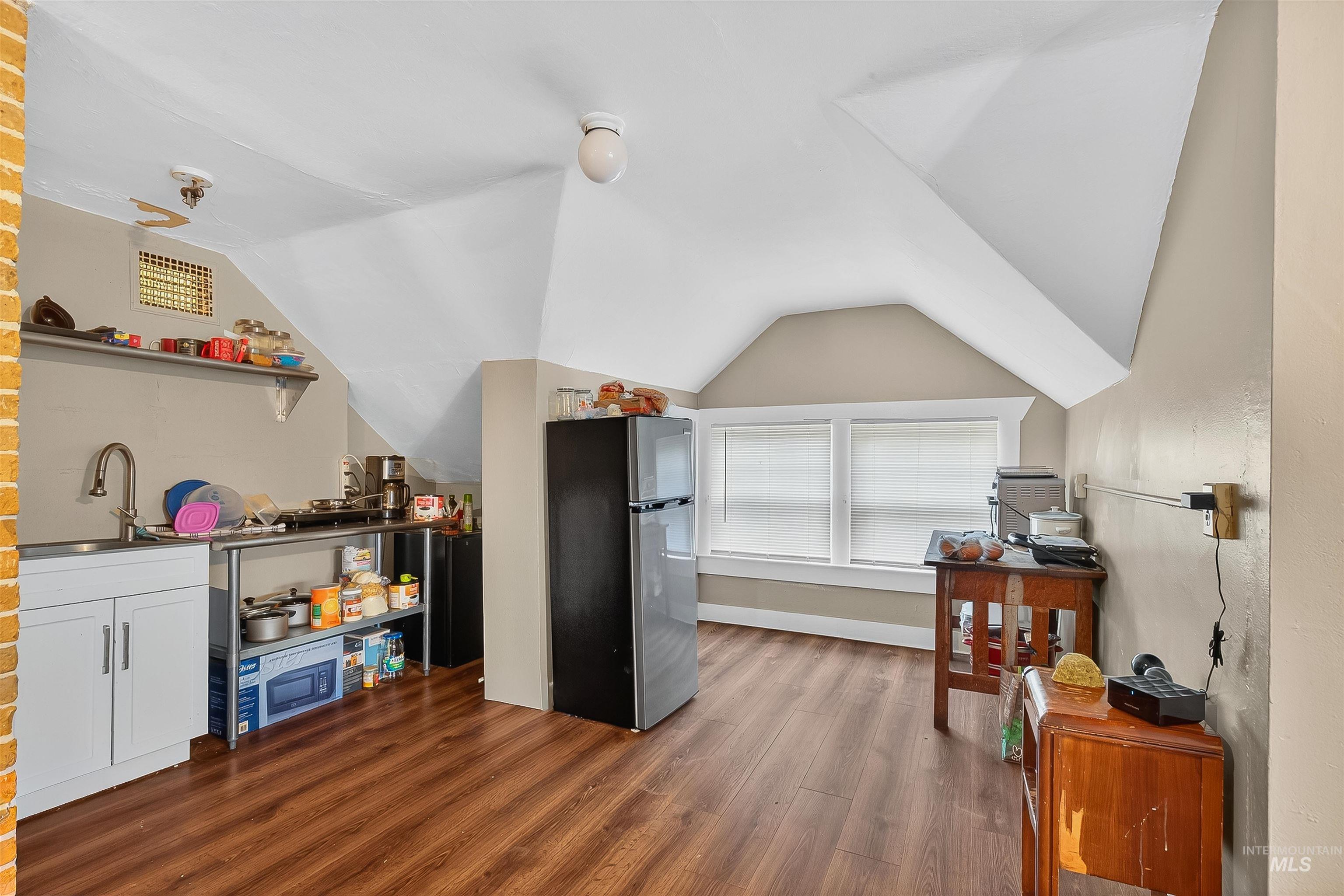 Interior space with dark wood finished floors and vaulted ceiling