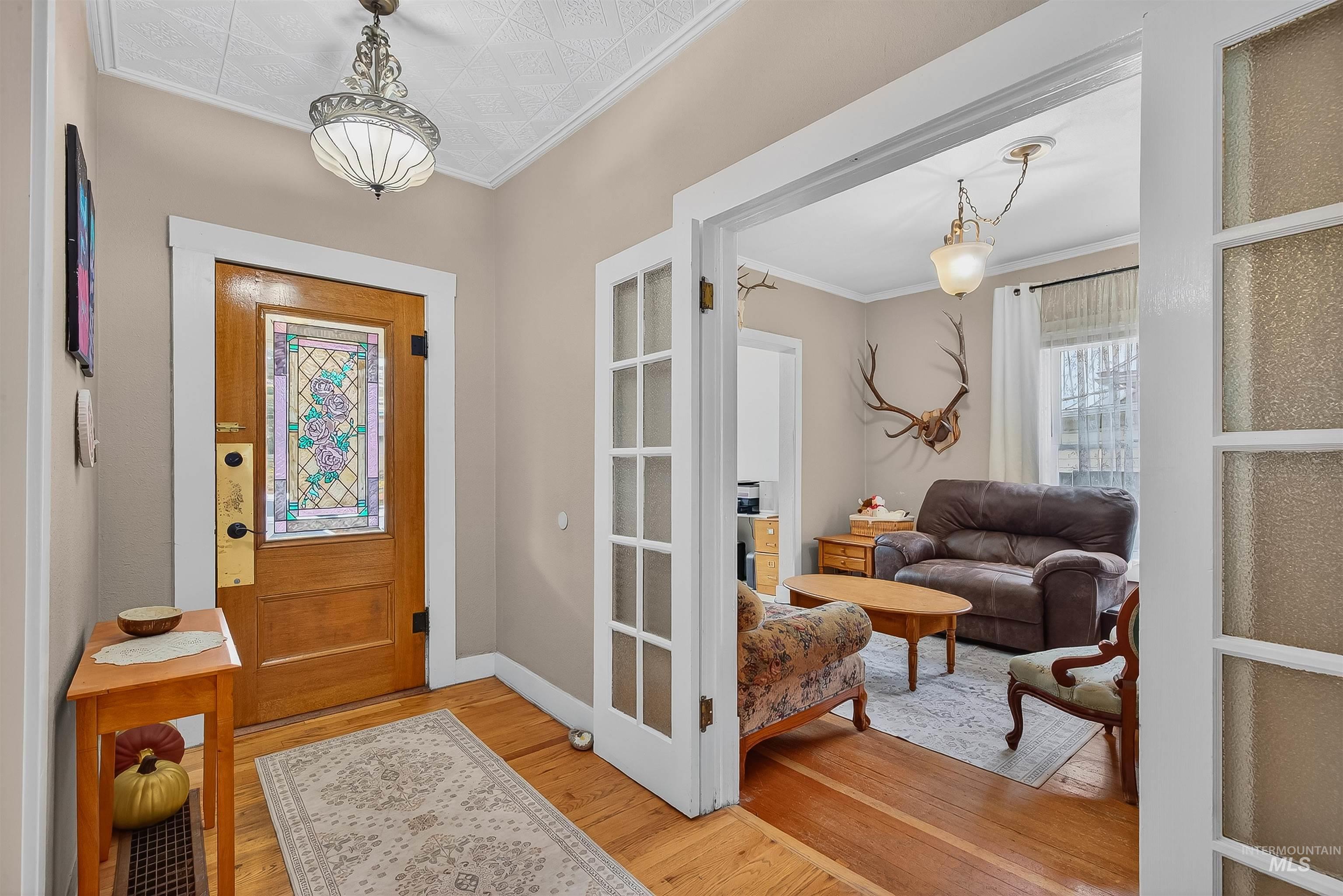 Foyer with ornamental molding and light wood finished floors