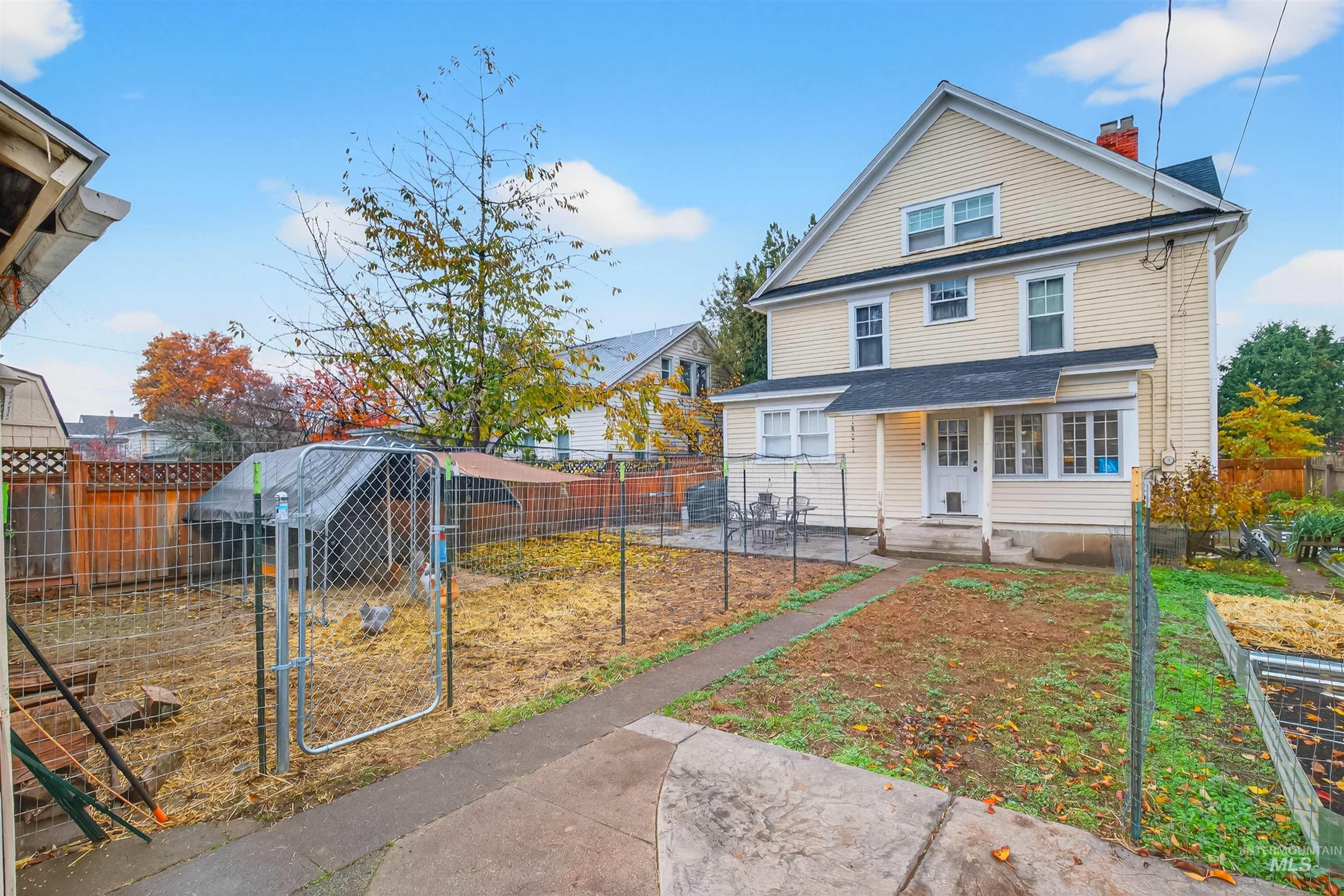 View of front facade with a chimney and a fenced backyard