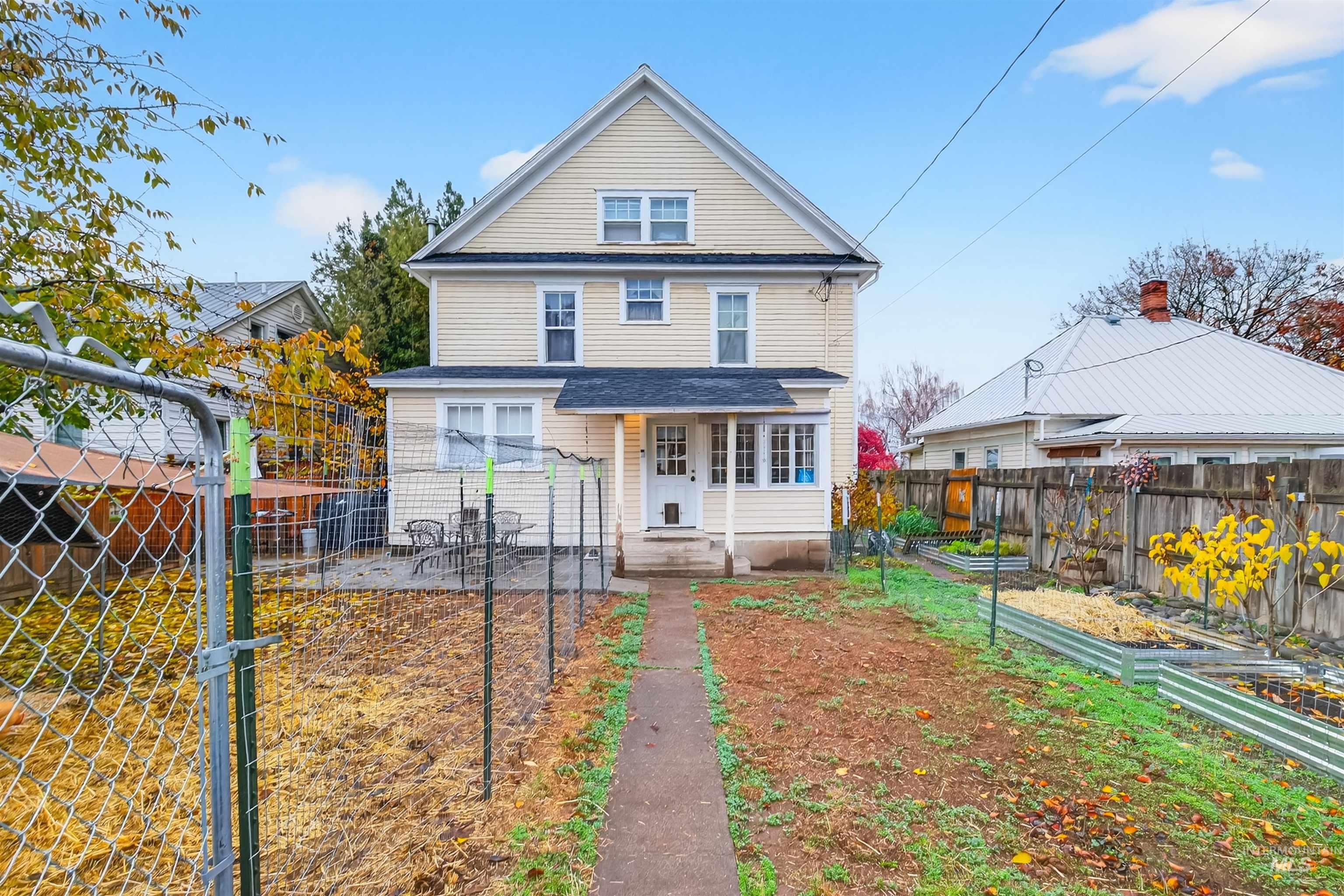 Rear view of property featuring a garden, a porch, and a fenced backyard