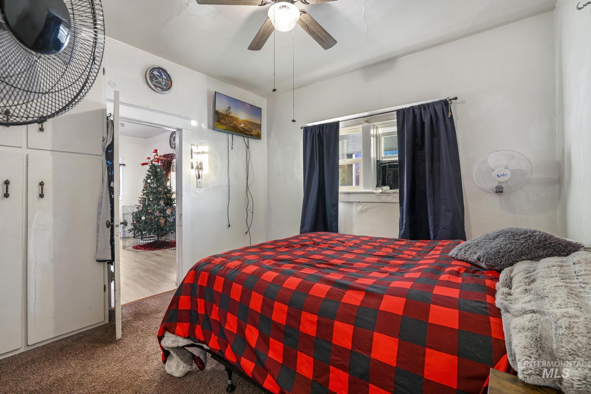 Bedroom featuring ceiling fan and dark colored carpet