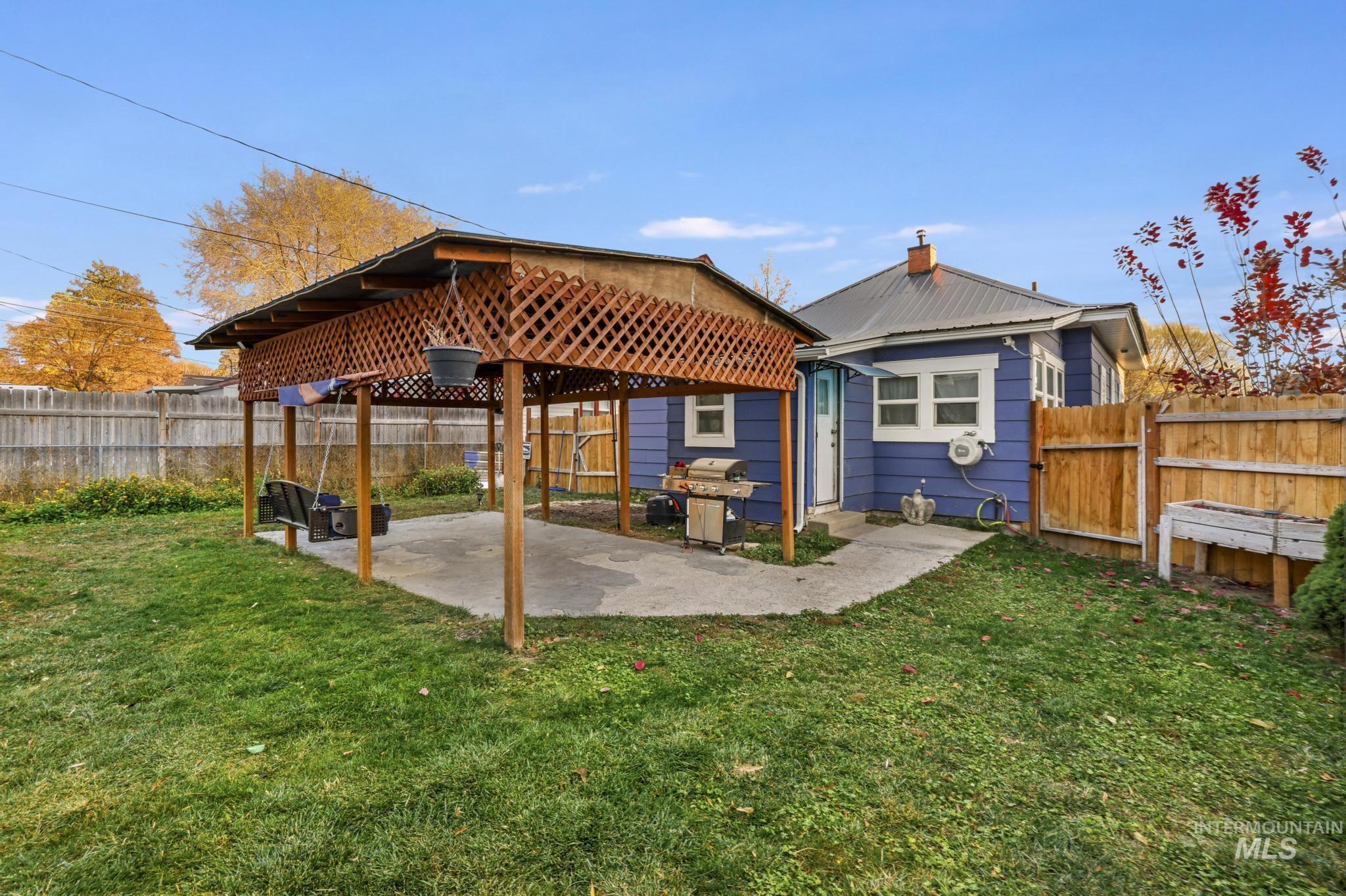 Rear view of property featuring a patio, a fenced backyard, and a gazebo