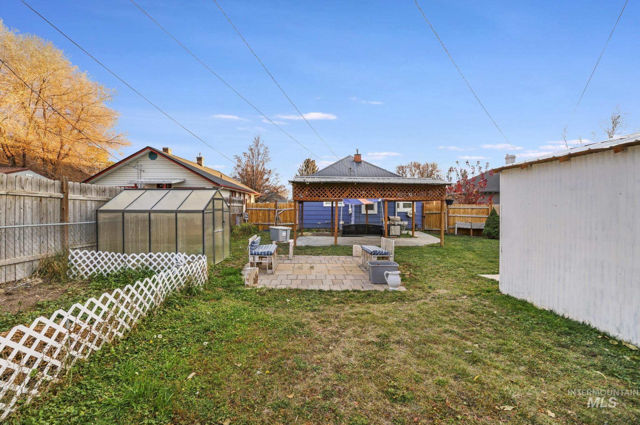 Fenced backyard with a patio, an exterior structure, and an outdoor structure