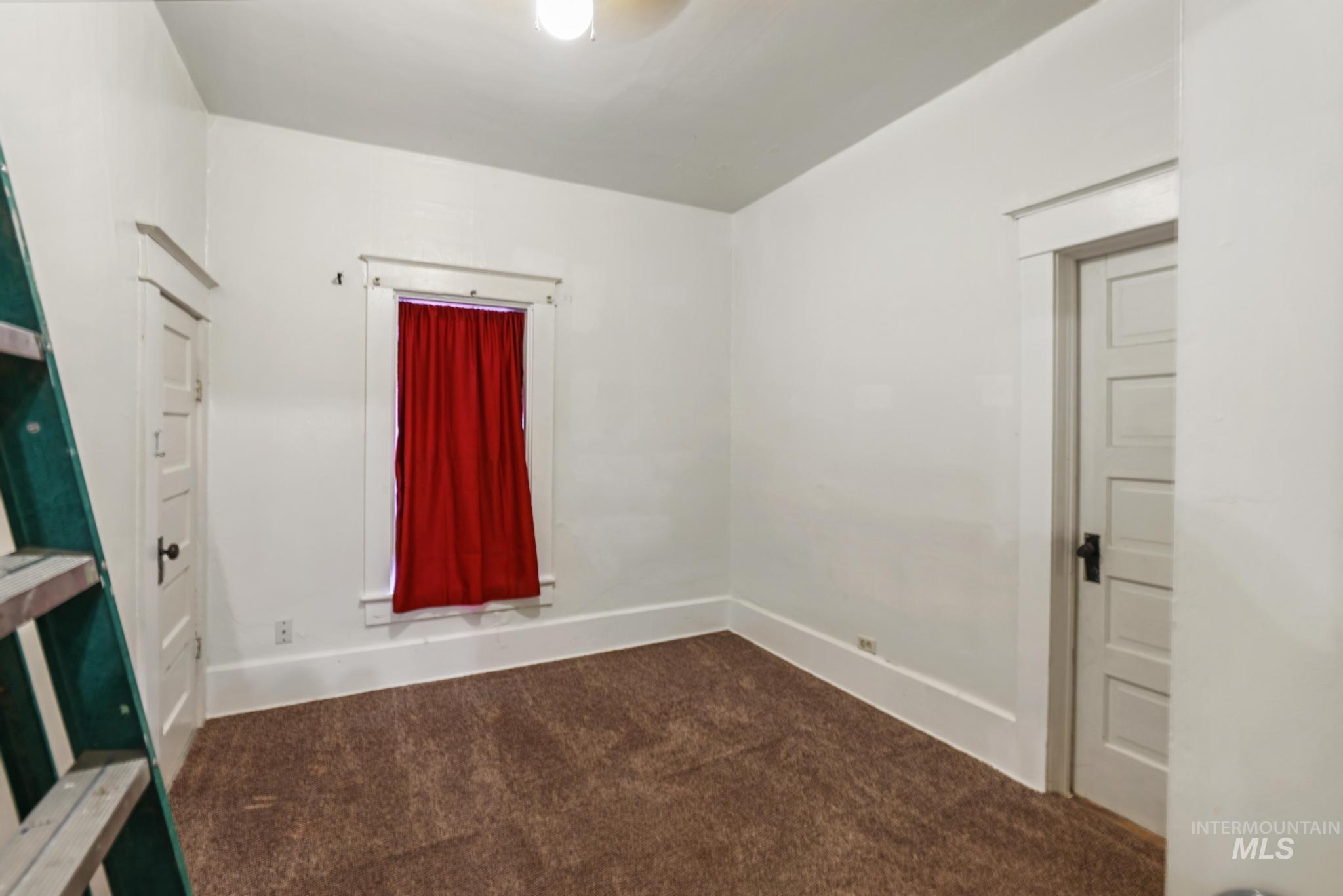 Unfurnished room featuring carpet floors and baseboards
