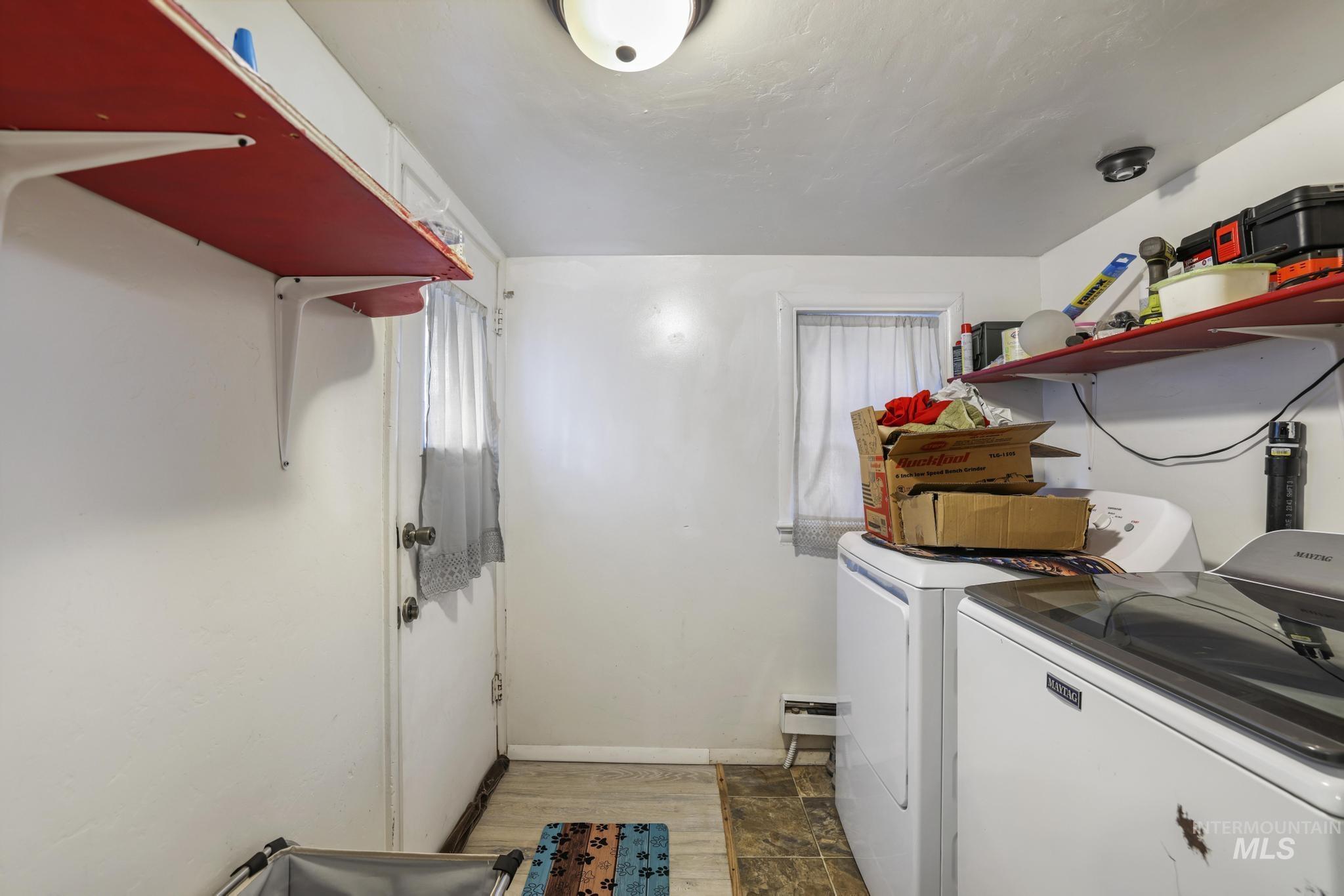 Washroom with washer and clothes dryer and dark wood-style floors