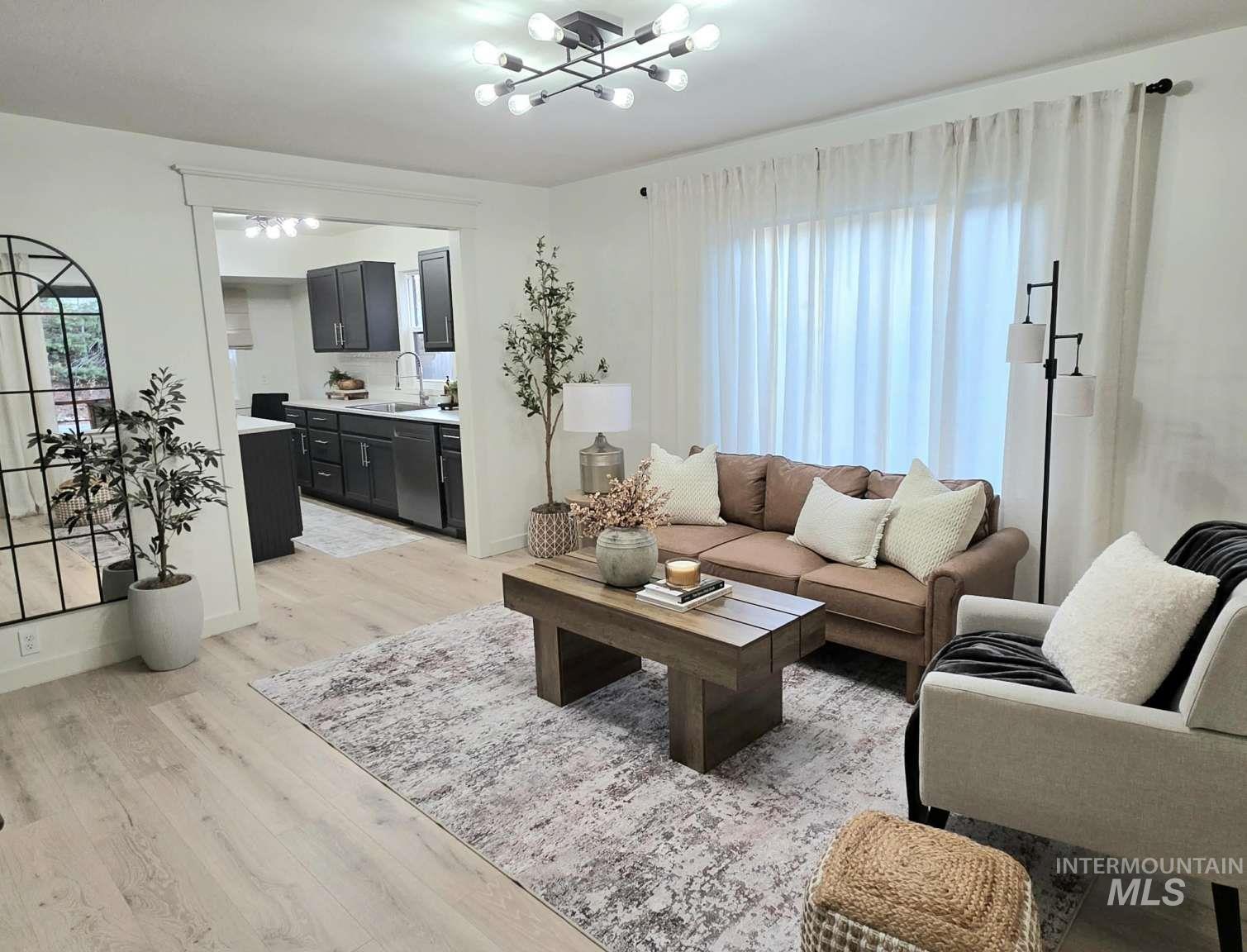 Living room featuring light wood-style flooring and a chandelier
