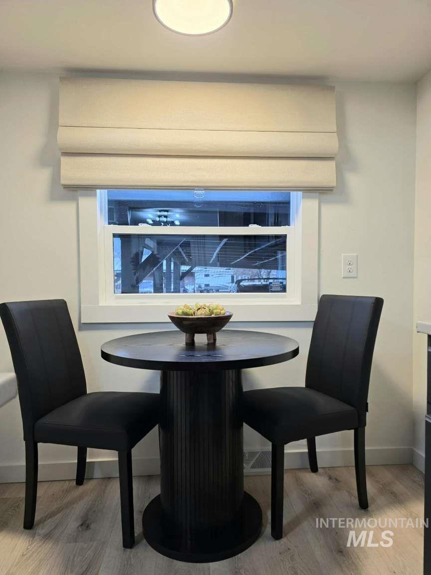 Dining space featuring light wood finished floors and a wall unit AC