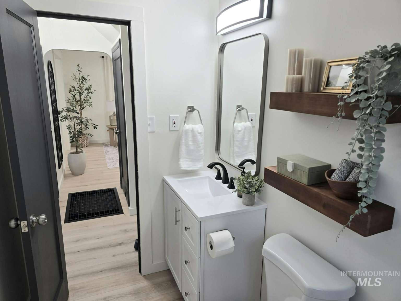Half bathroom featuring vanity and light wood finished floors