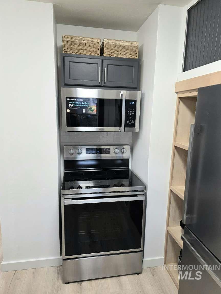 Kitchen with stainless steel appliances and light wood-style flooring
