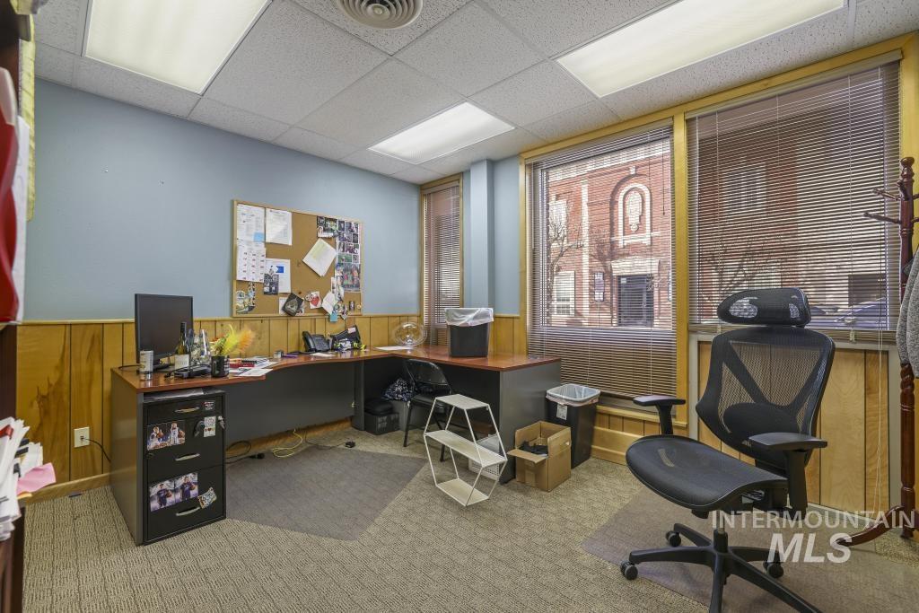 Home office featuring wooden walls, a drop ceiling, wainscoting, and healthy amount of natural light