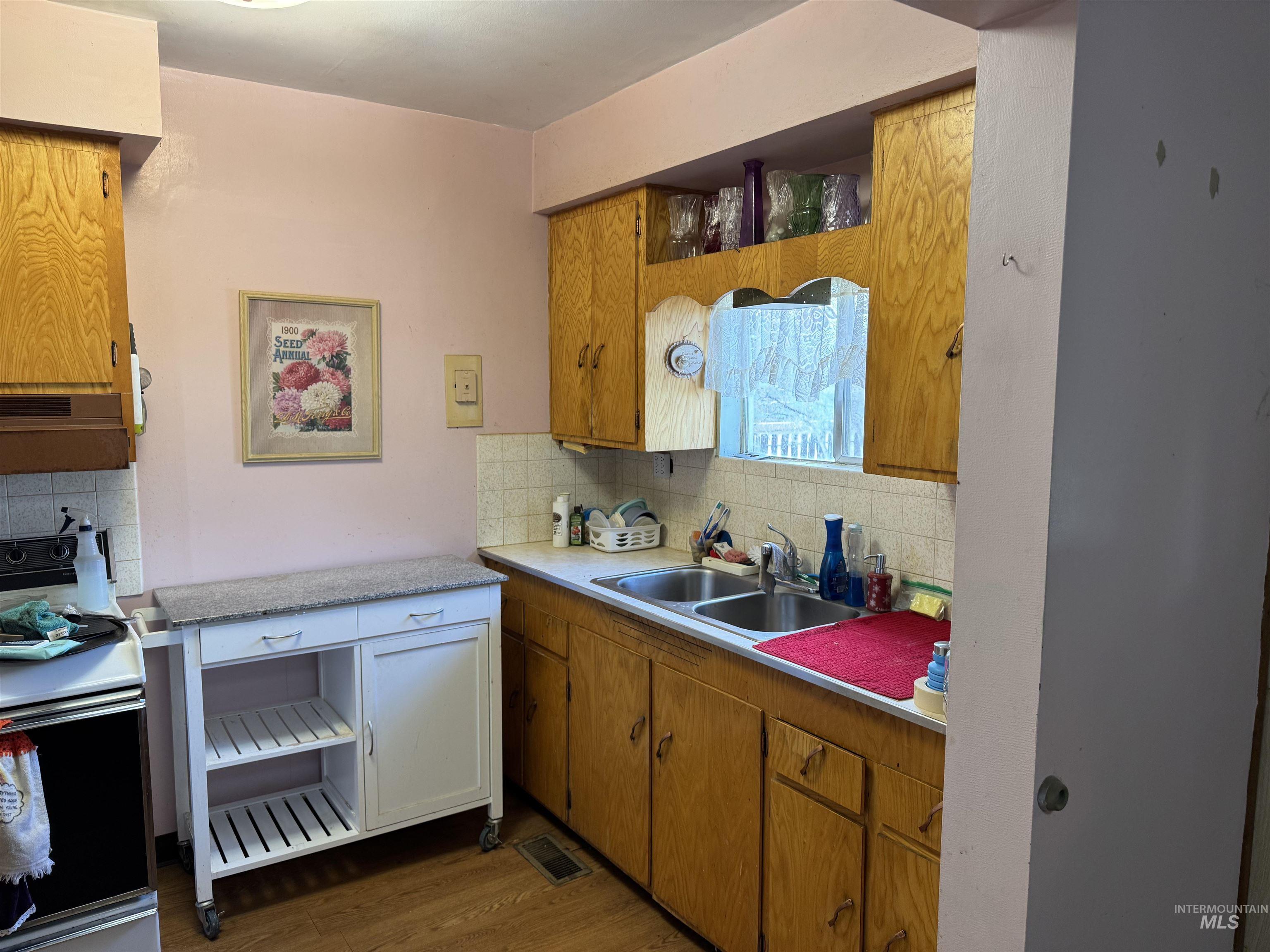 Kitchen featuring tasteful backsplash, electric stove, light countertops, and open shelves