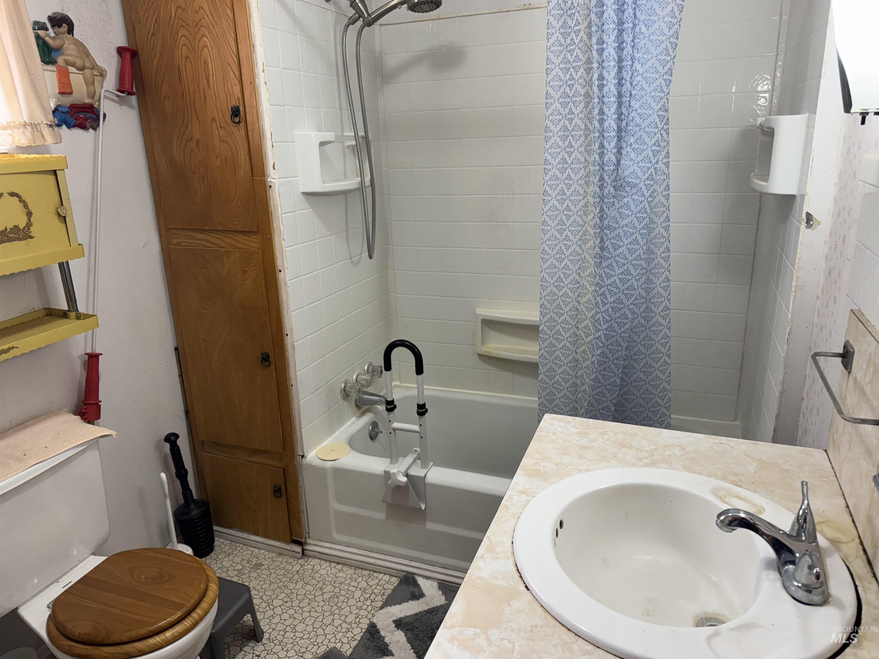 Bathroom featuring vanity and shower / bath combination with curtain