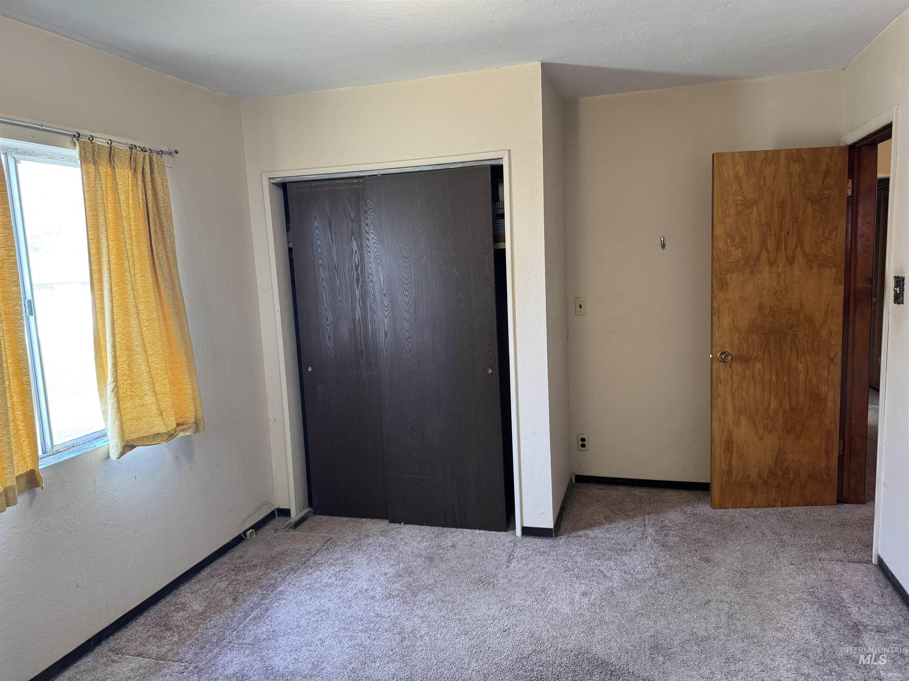 Unfurnished bedroom with carpet and a closet
