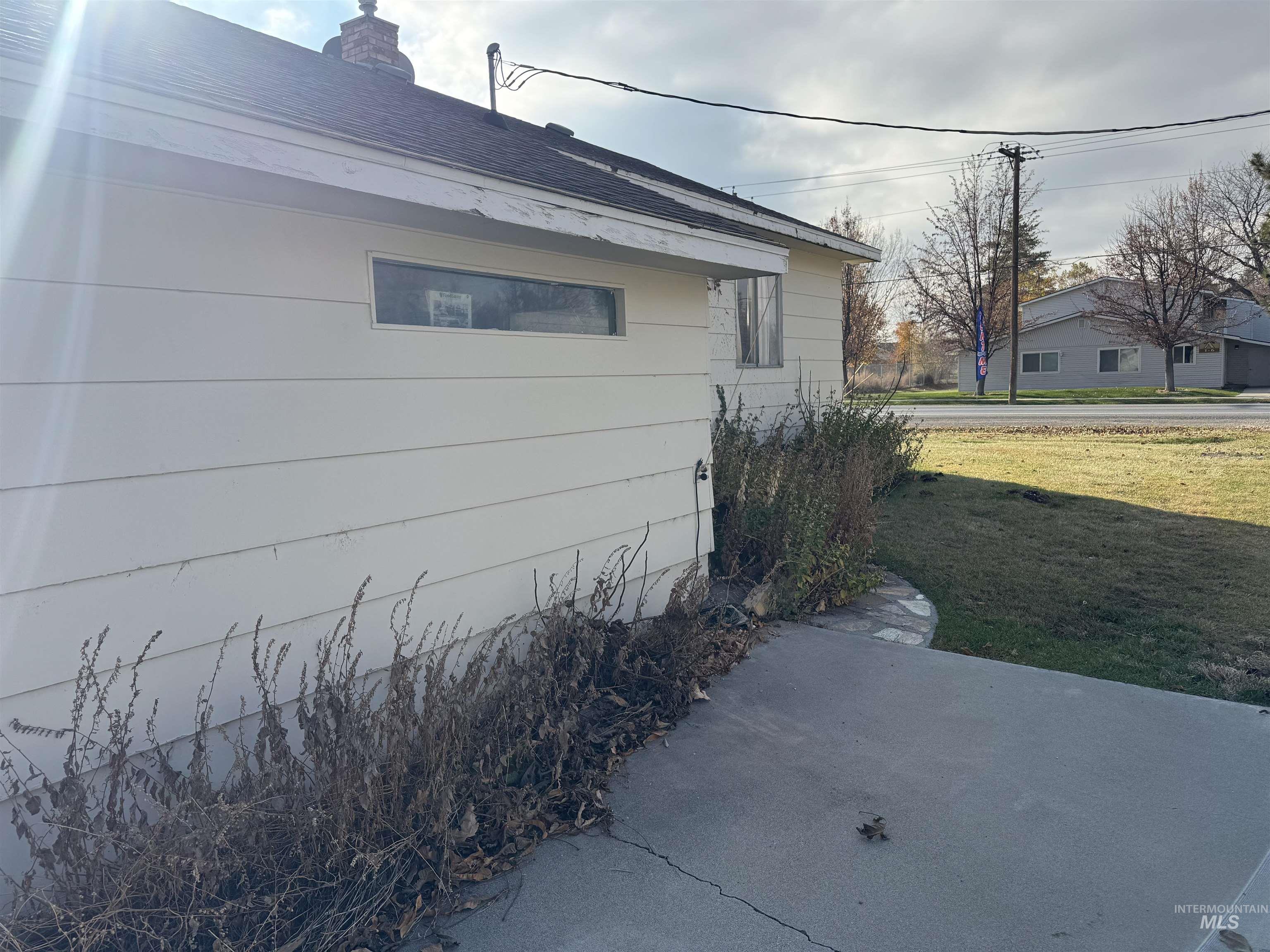 View of side of property featuring a yard, a chimney, and a shingled roof