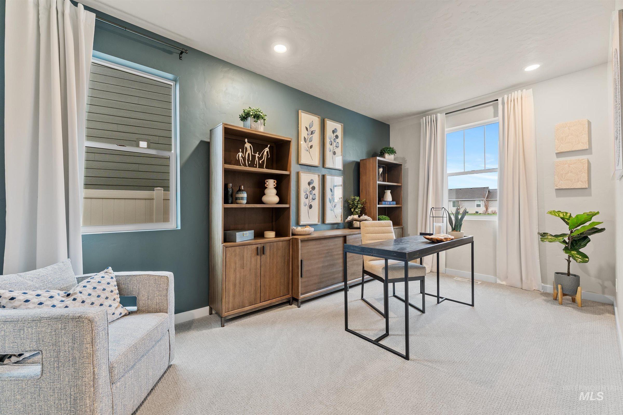 Home office with light colored carpet and recessed lighting