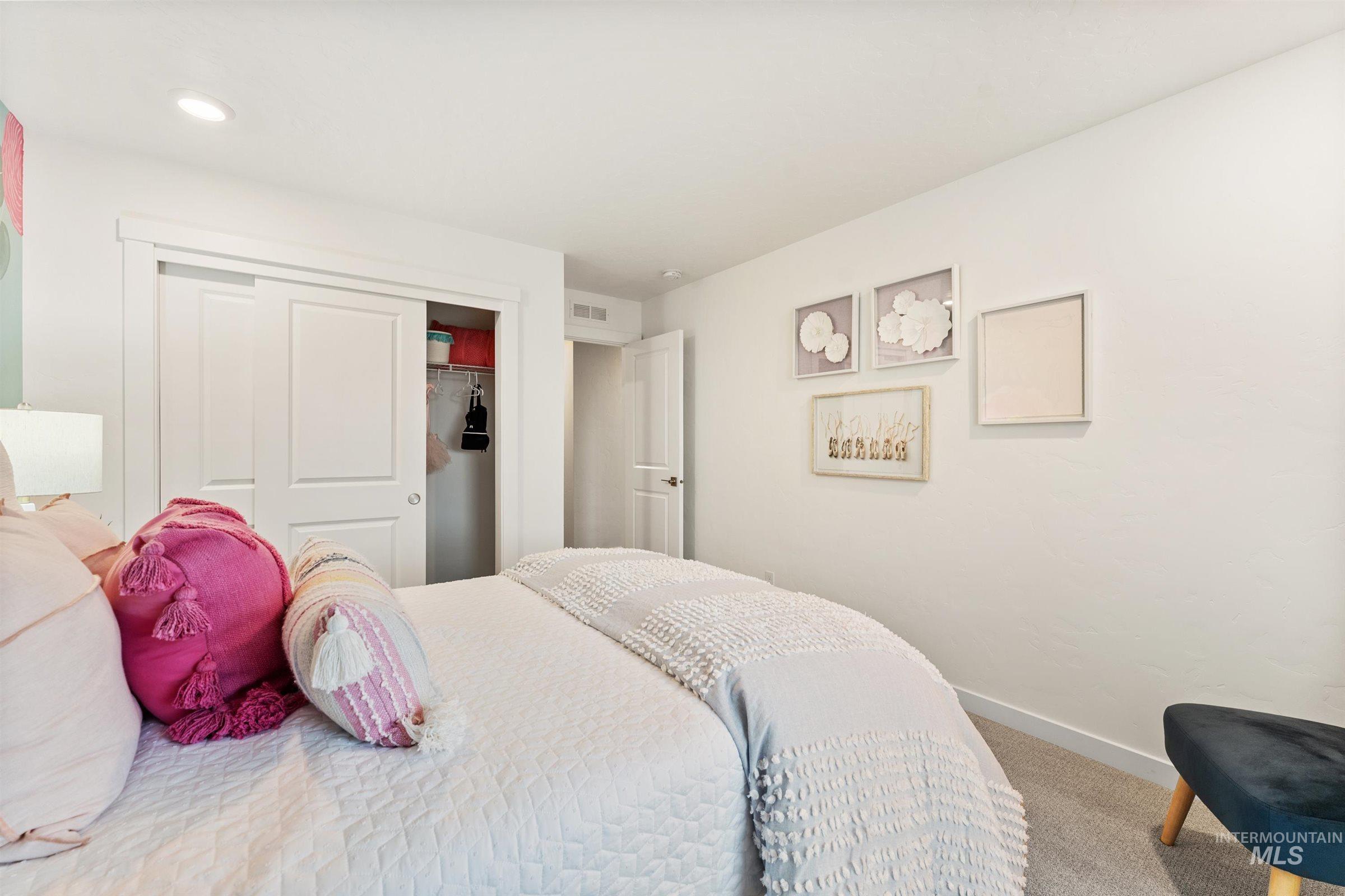 Carpeted bedroom featuring baseboards and a closet
