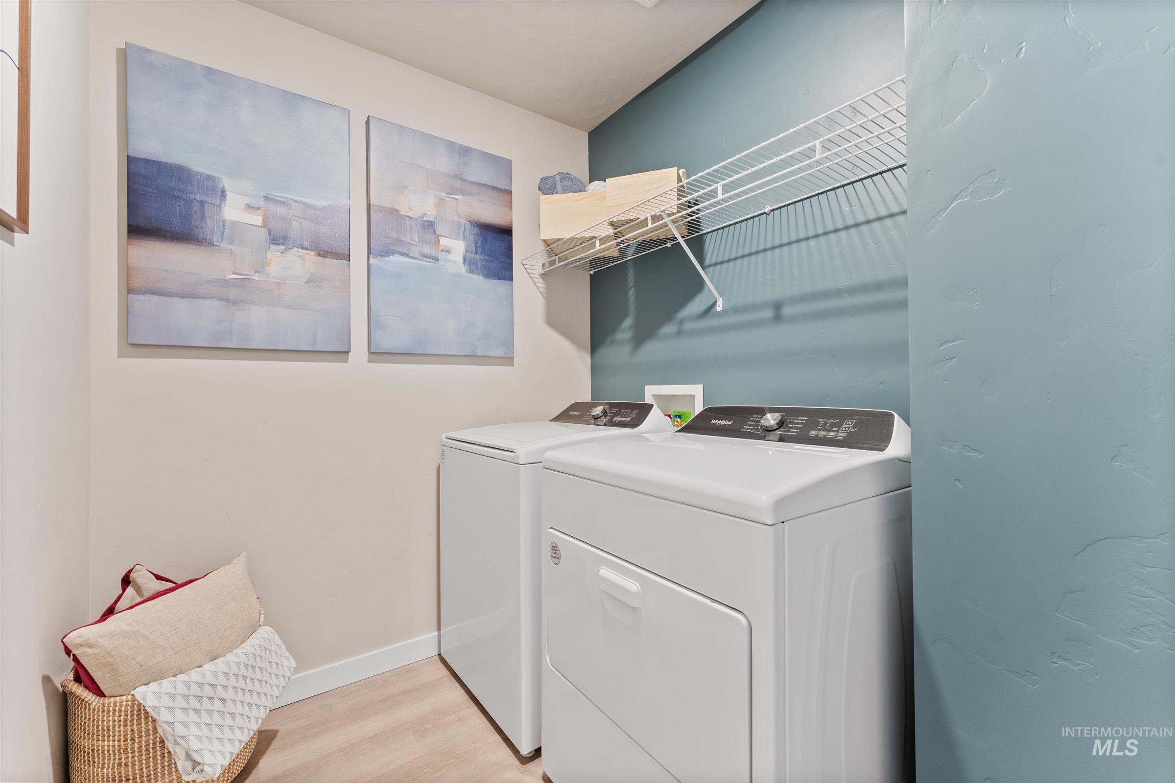 Laundry area featuring light wood finished floors and washer and dryer