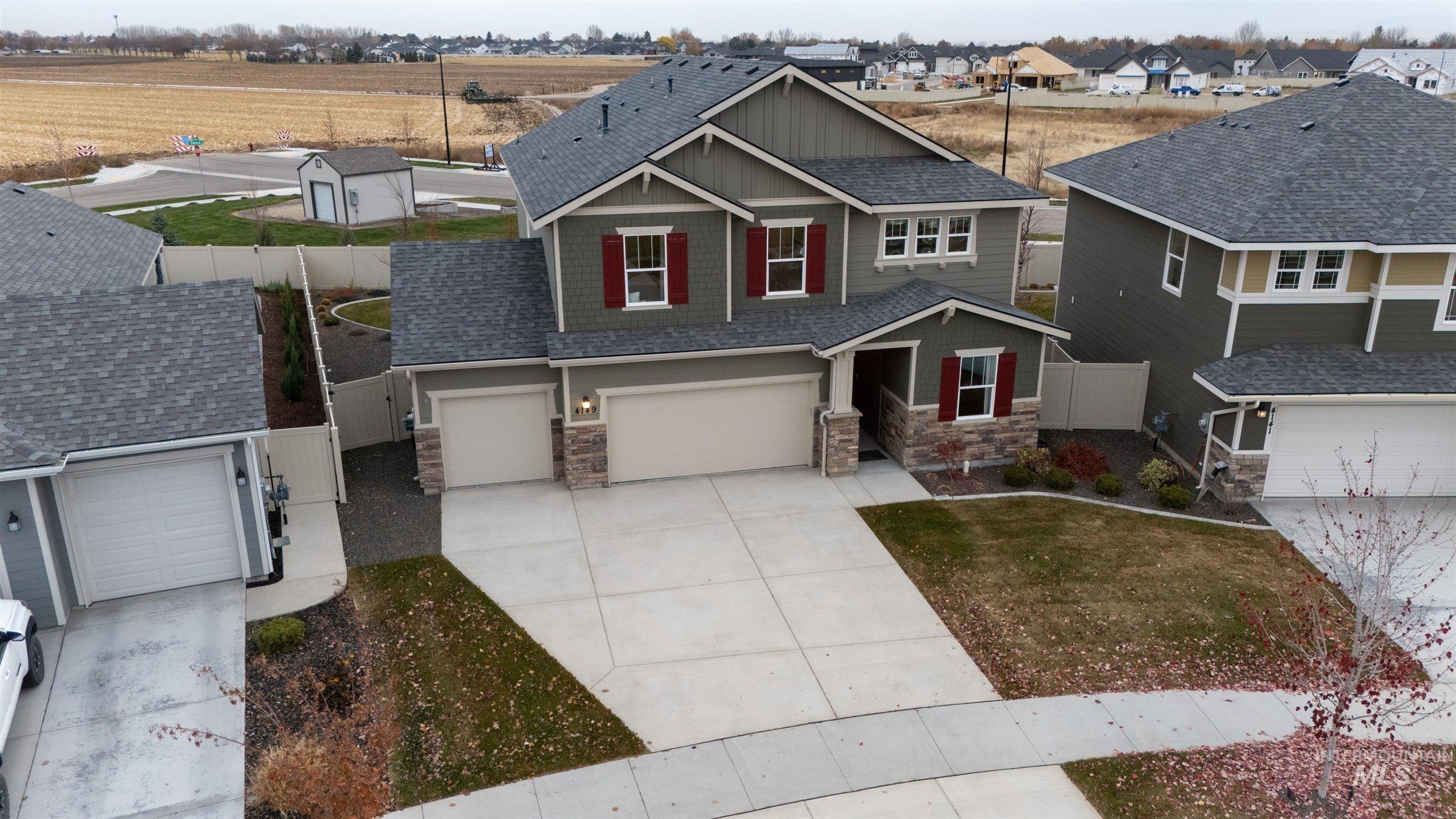 Craftsman-style house with a residential view, stone siding, driveway, board and batten siding, and a garage