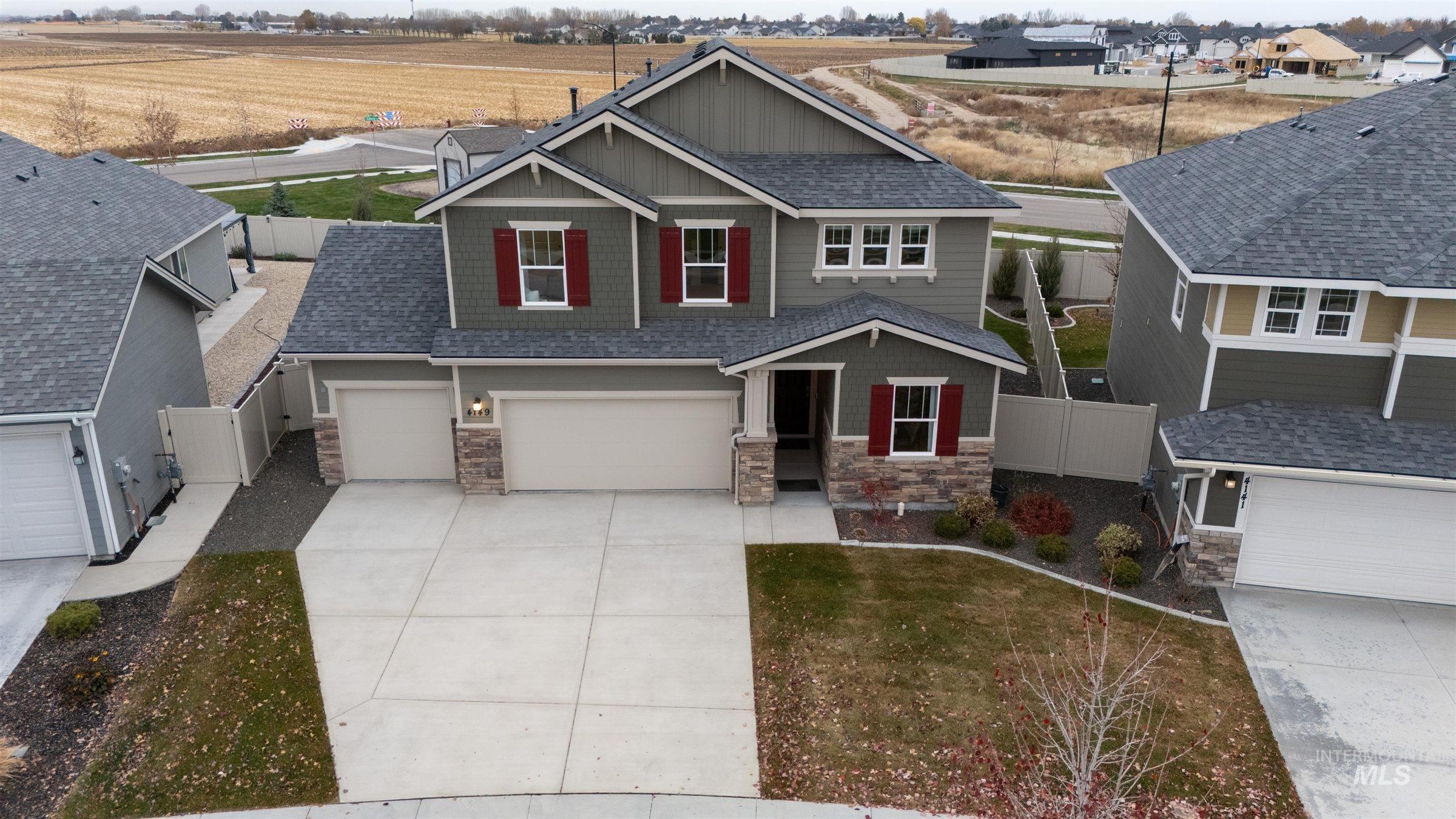 Craftsman-style home with stone siding, concrete driveway, a shingled roof, board and batten siding, and a garage