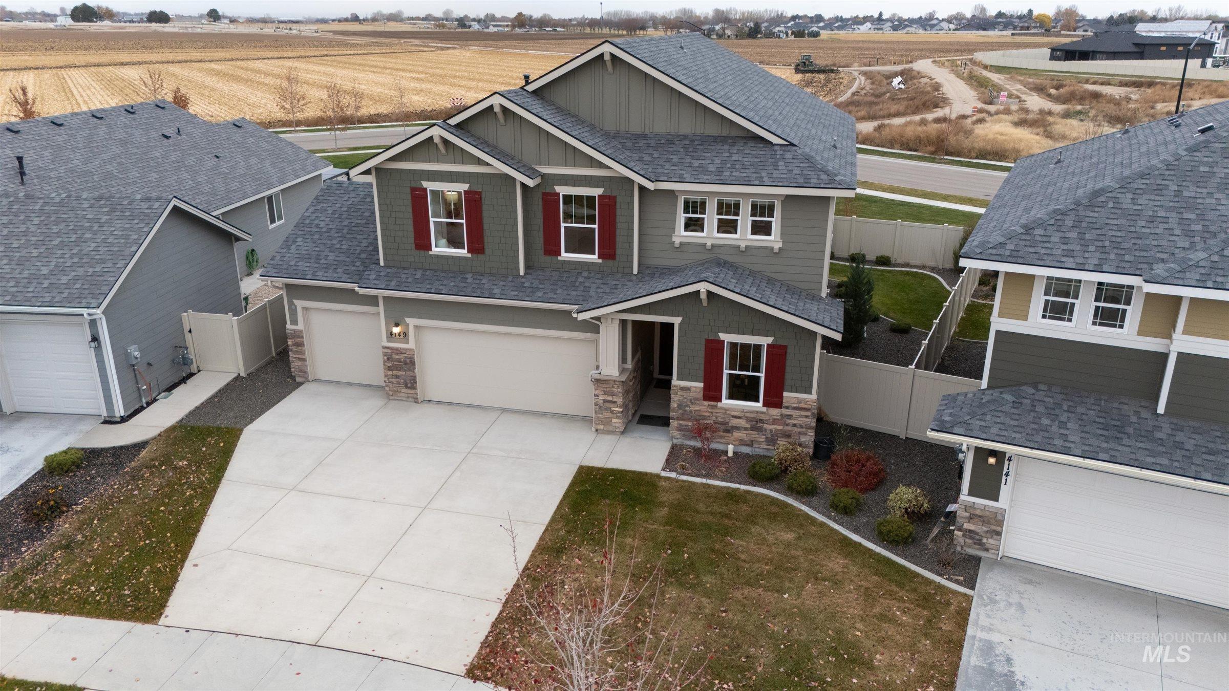 Craftsman-style house featuring board and batten siding, stone siding, concrete driveway, and roof with shingles