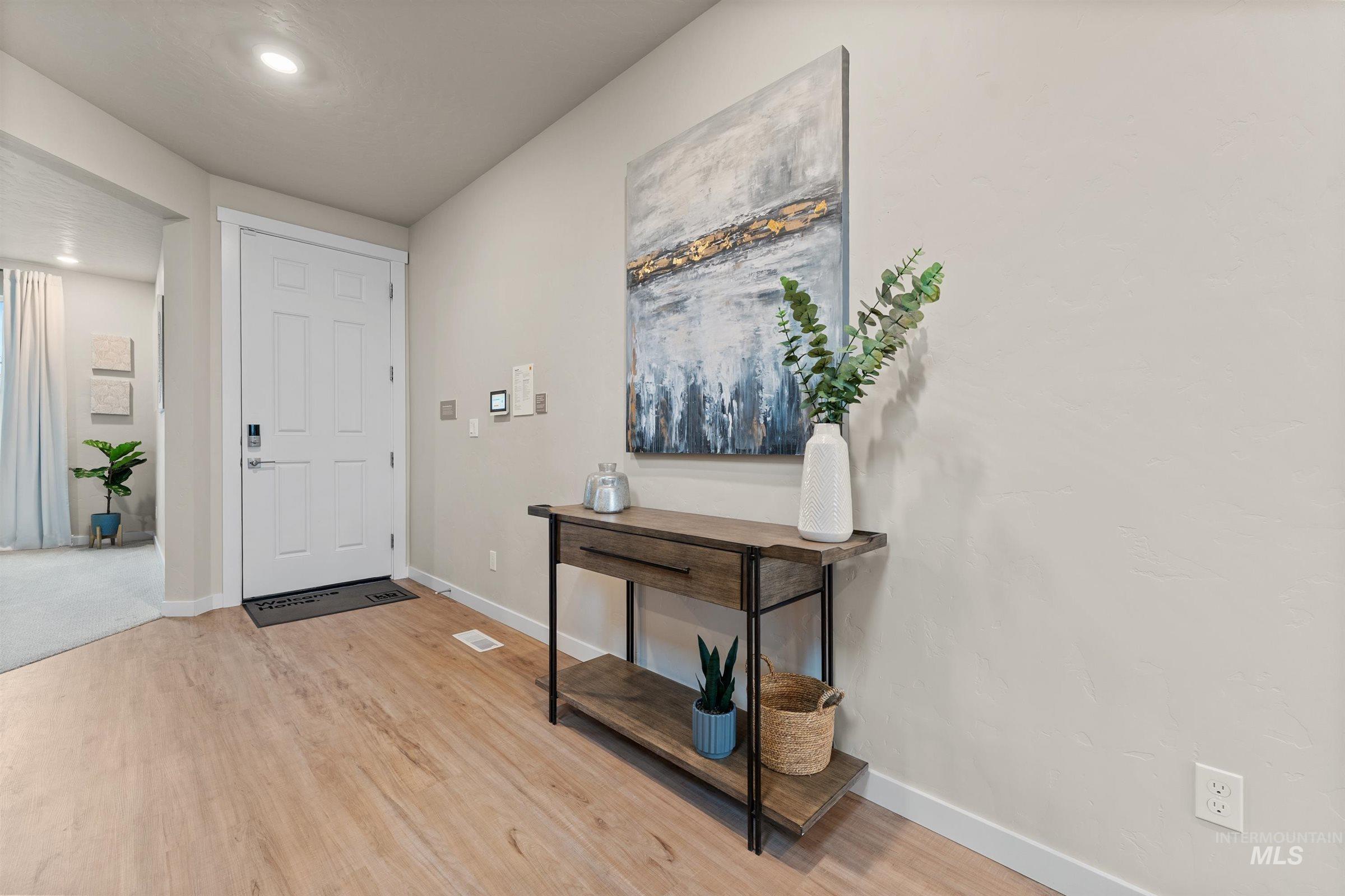 Foyer with baseboards and light wood finished floors