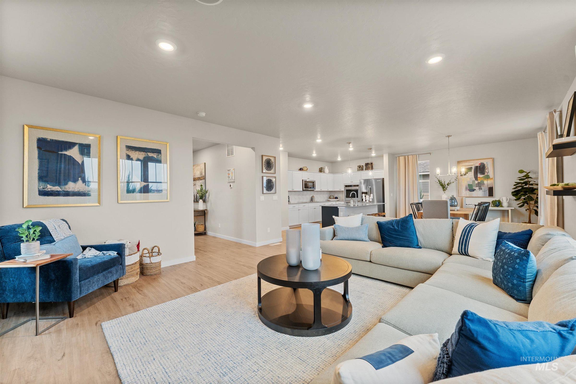 Living area featuring light wood-style flooring, recessed lighting, and a chandelier