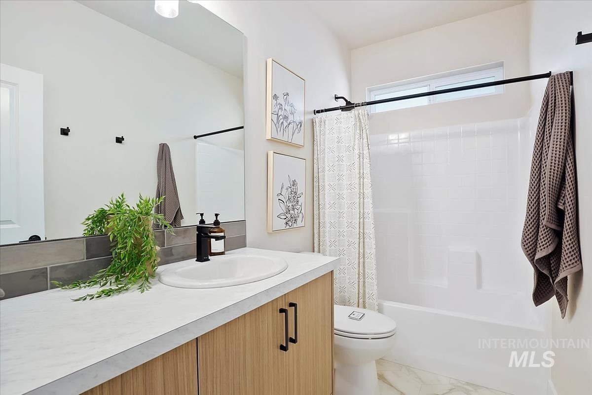 Bathroom with shower / bath combination with curtain and vanity