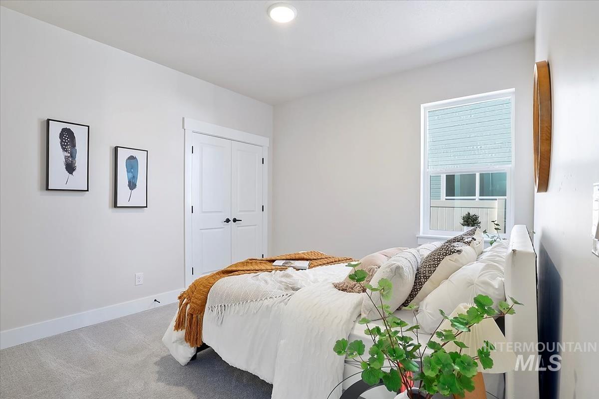 Carpeted bedroom with baseboards and a closet
