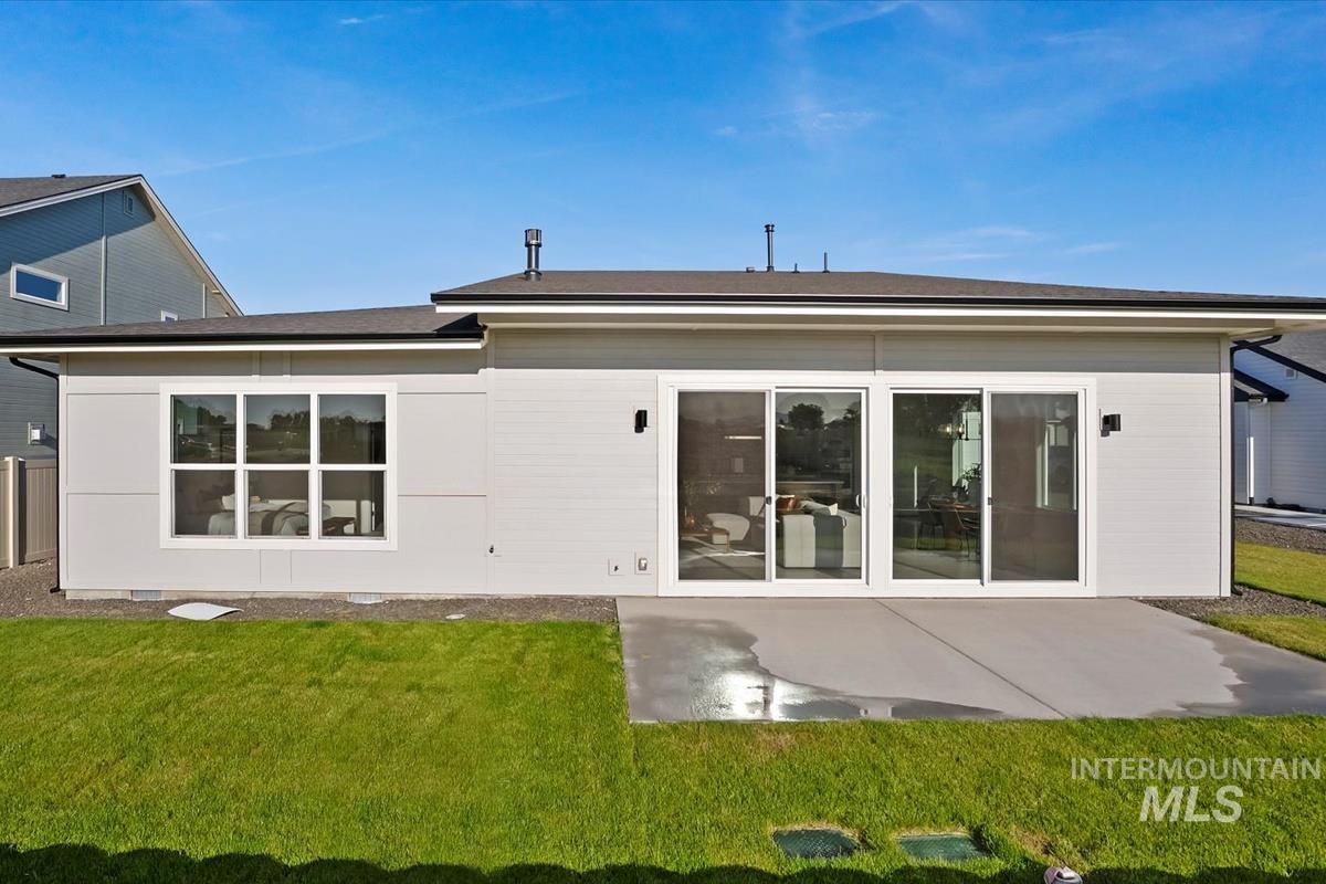 Rear view of house featuring a yard and a patio area