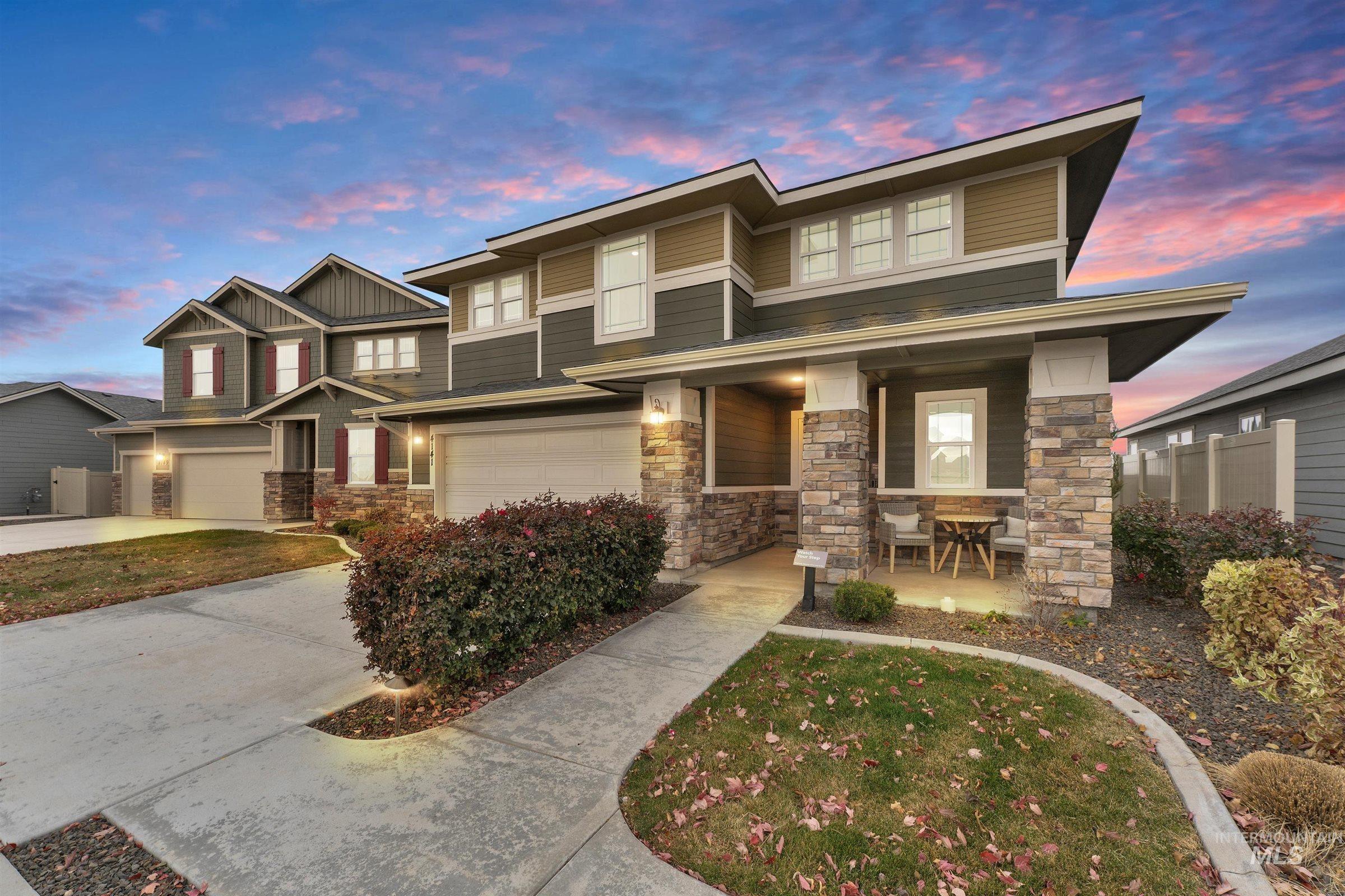 View of front of property with stone siding, covered porch, concrete driveway, and a garage