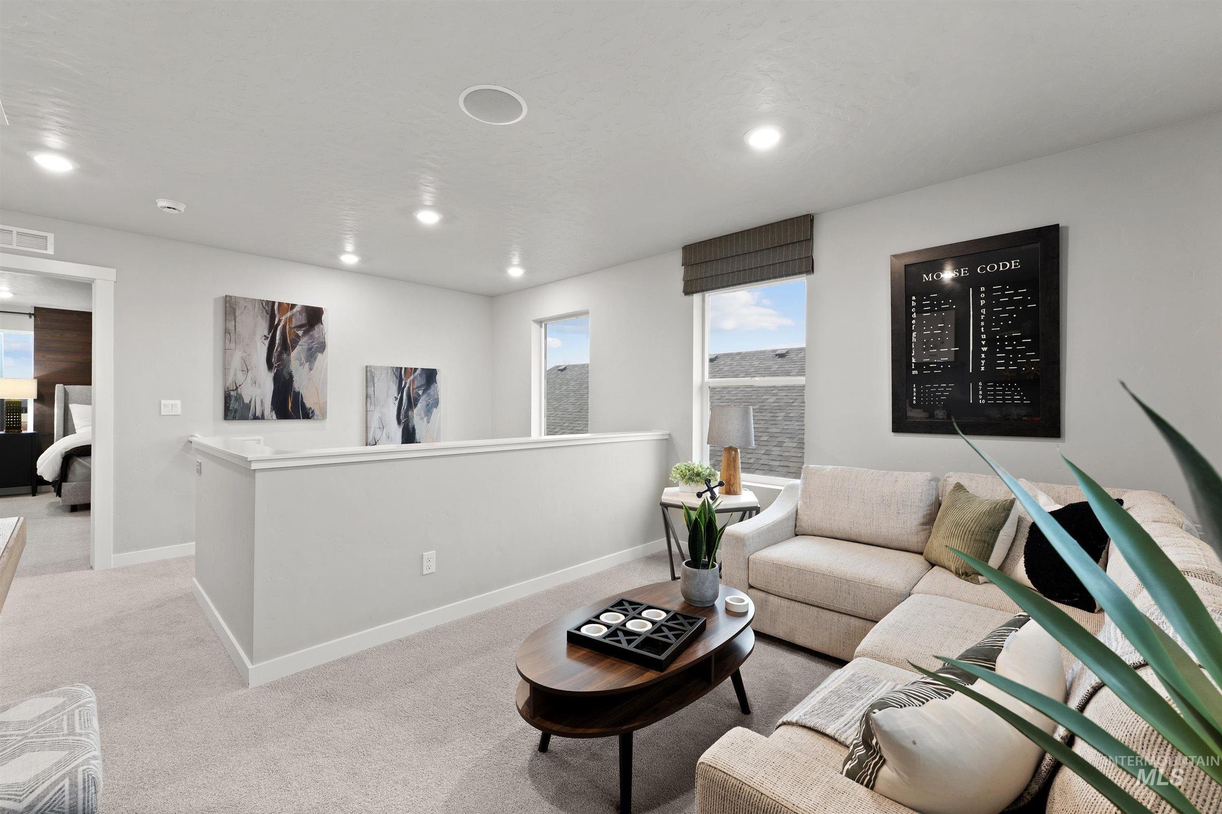 Carpeted living area with baseboards and recessed lighting