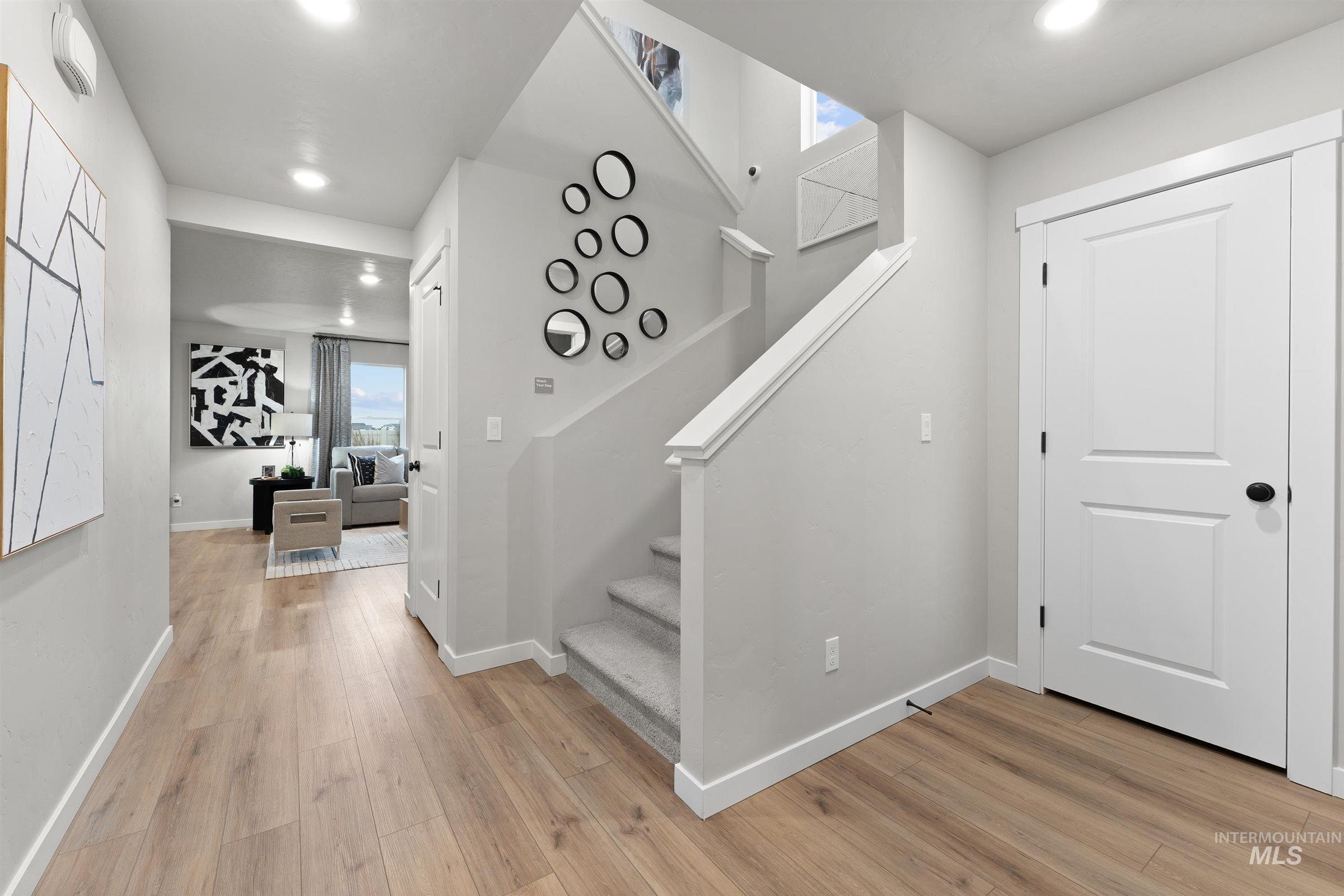 Stairs with plenty of natural light, recessed lighting, and wood finished floors