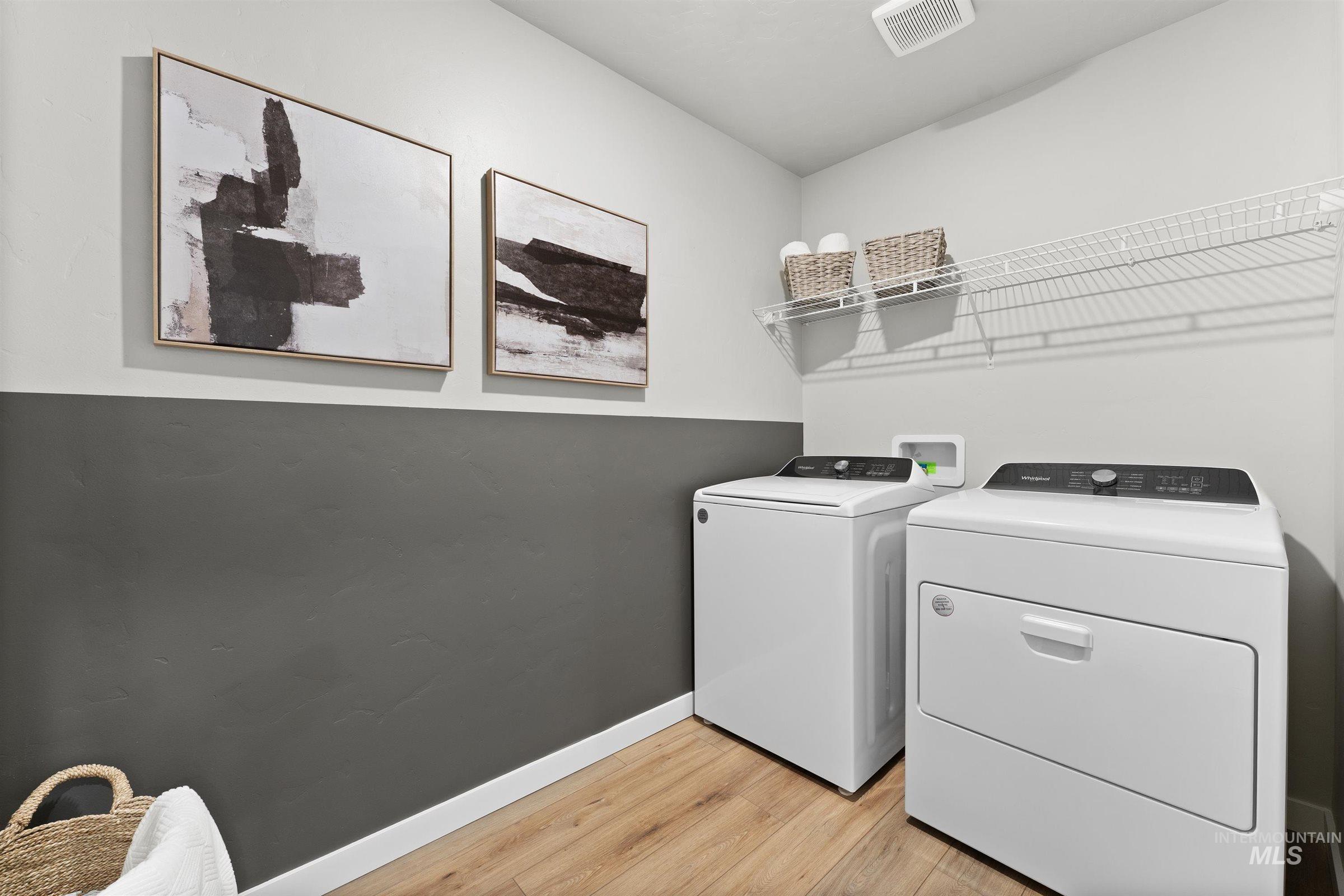 Laundry area featuring light wood finished floors and washer and dryer