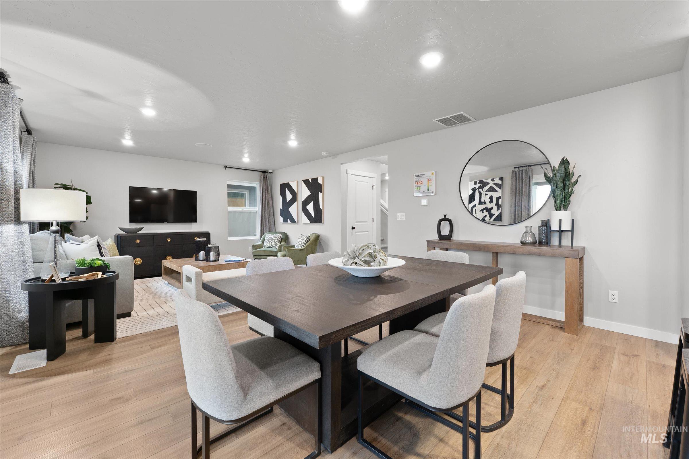 Dining area with light wood finished floors and recessed lighting
