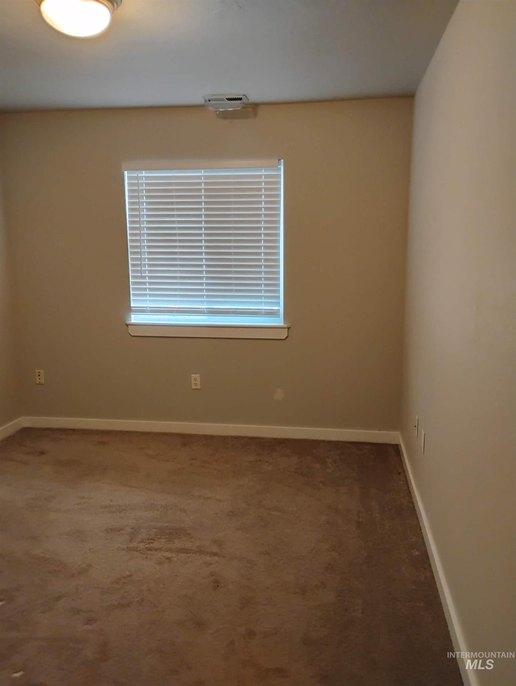 Unfurnished room featuring dark carpet