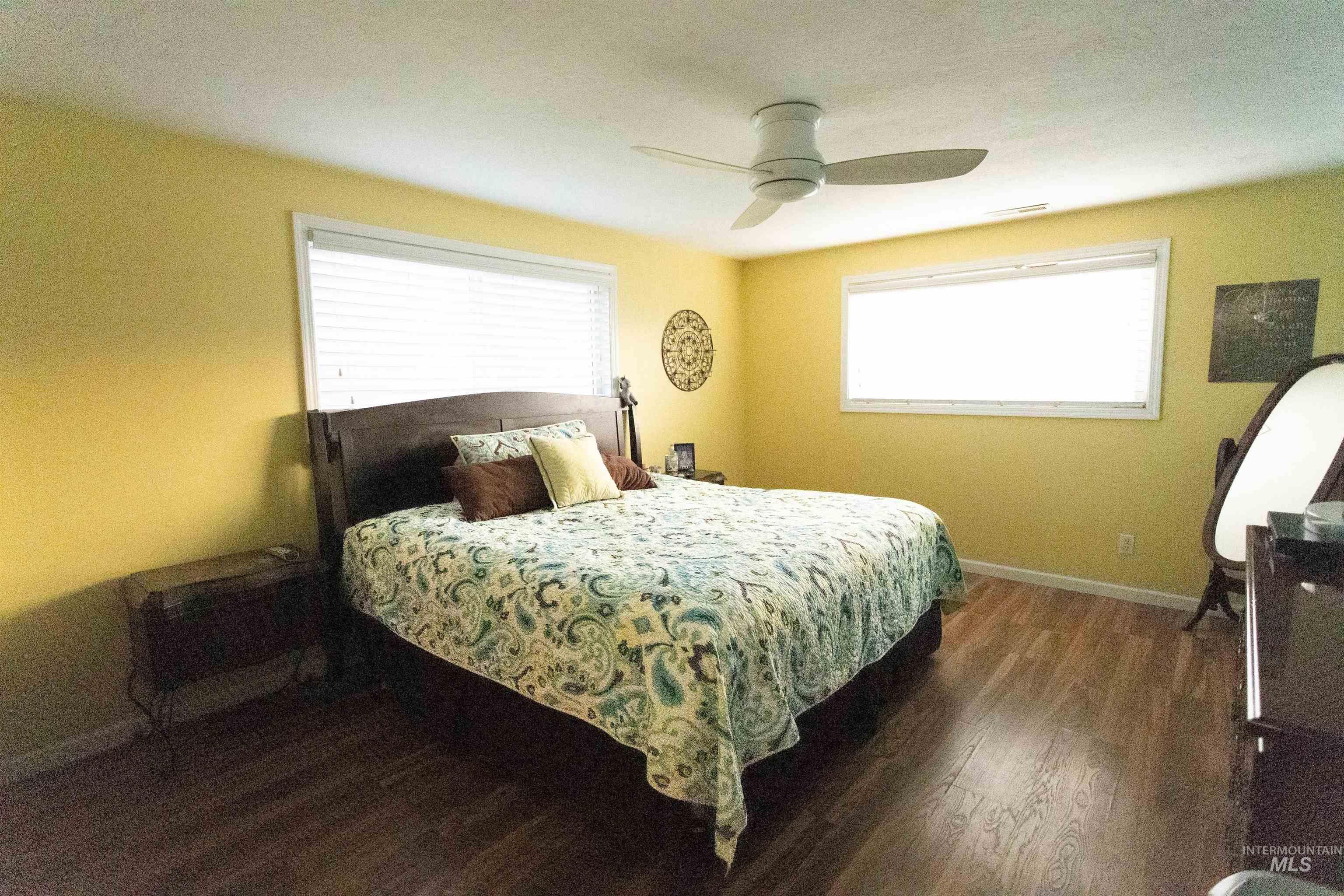Bedroom with dark wood-type flooring and a ceiling fan