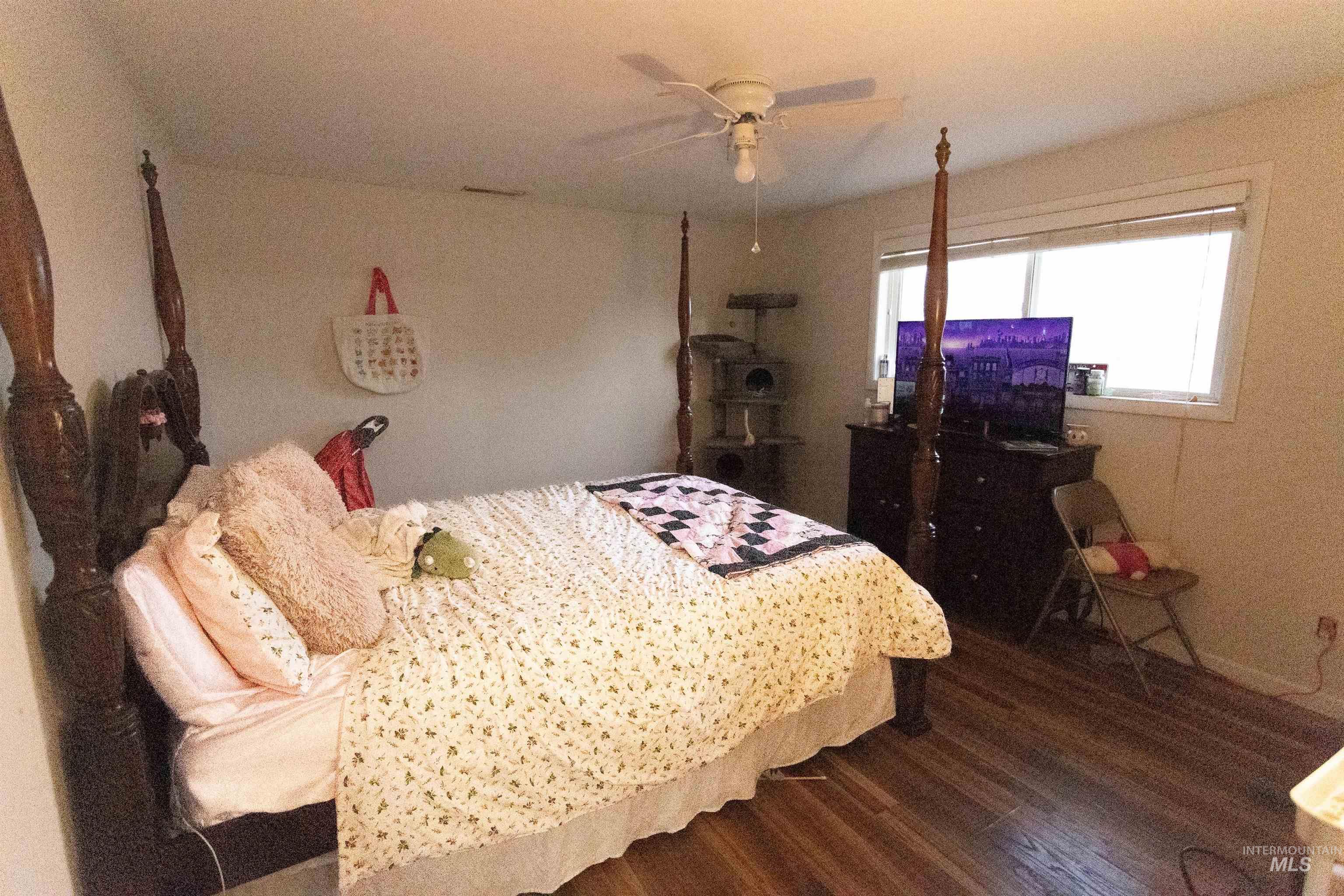 Bedroom featuring dark wood-style floors and a ceiling fan