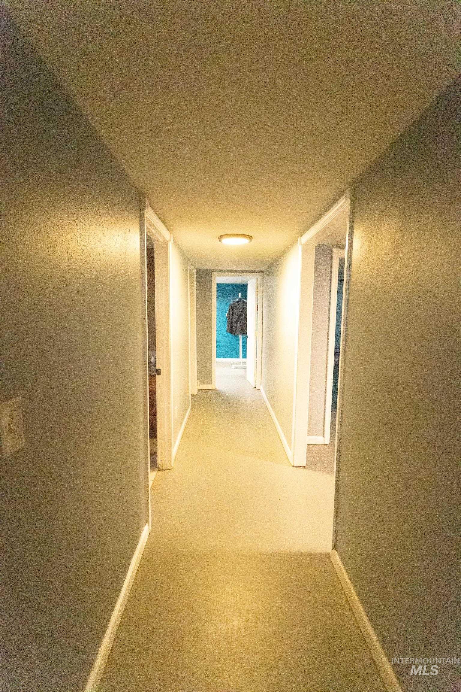 Corridor with carpet flooring and a textured ceiling