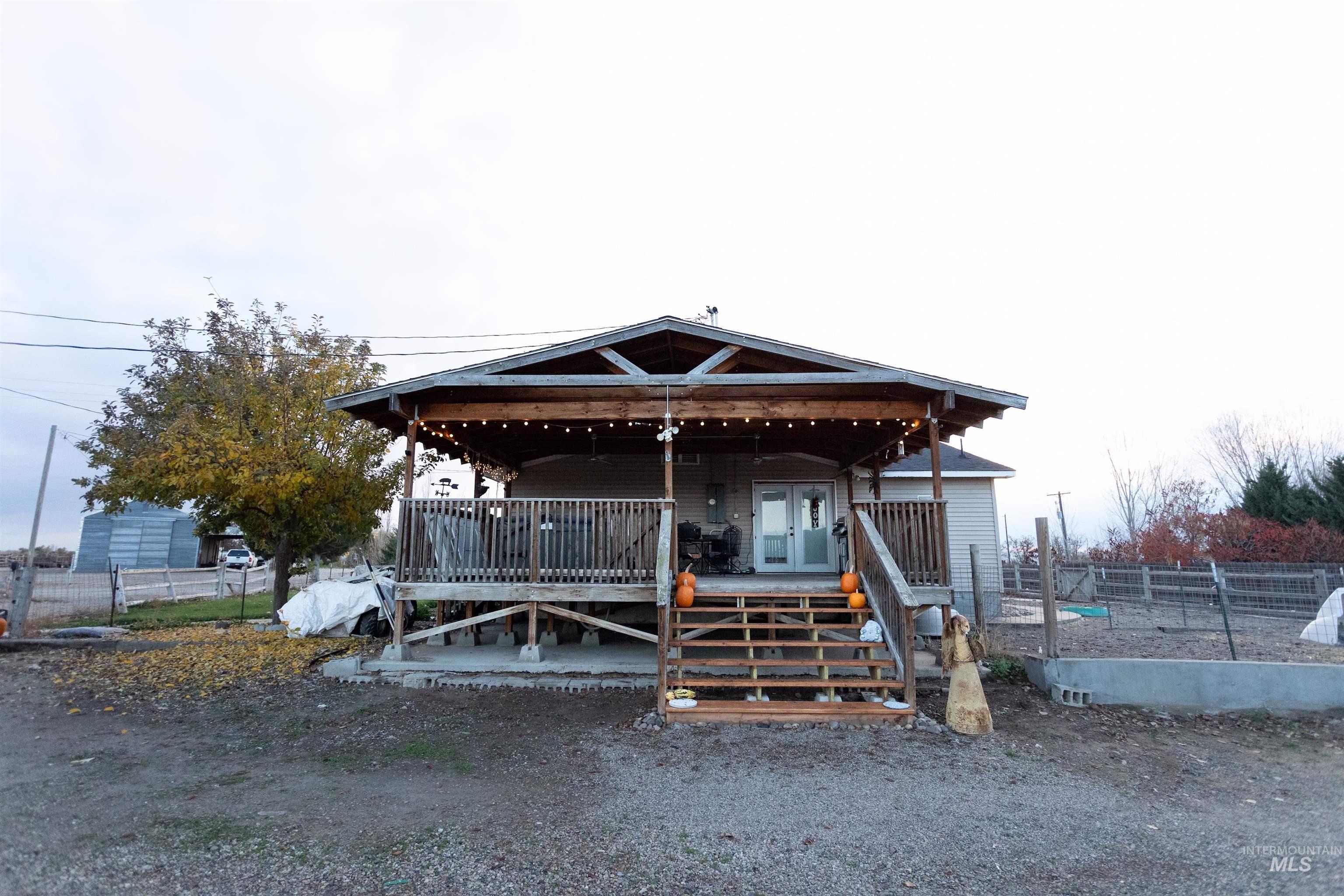 View of front of home with ceiling fan and a wooden deck