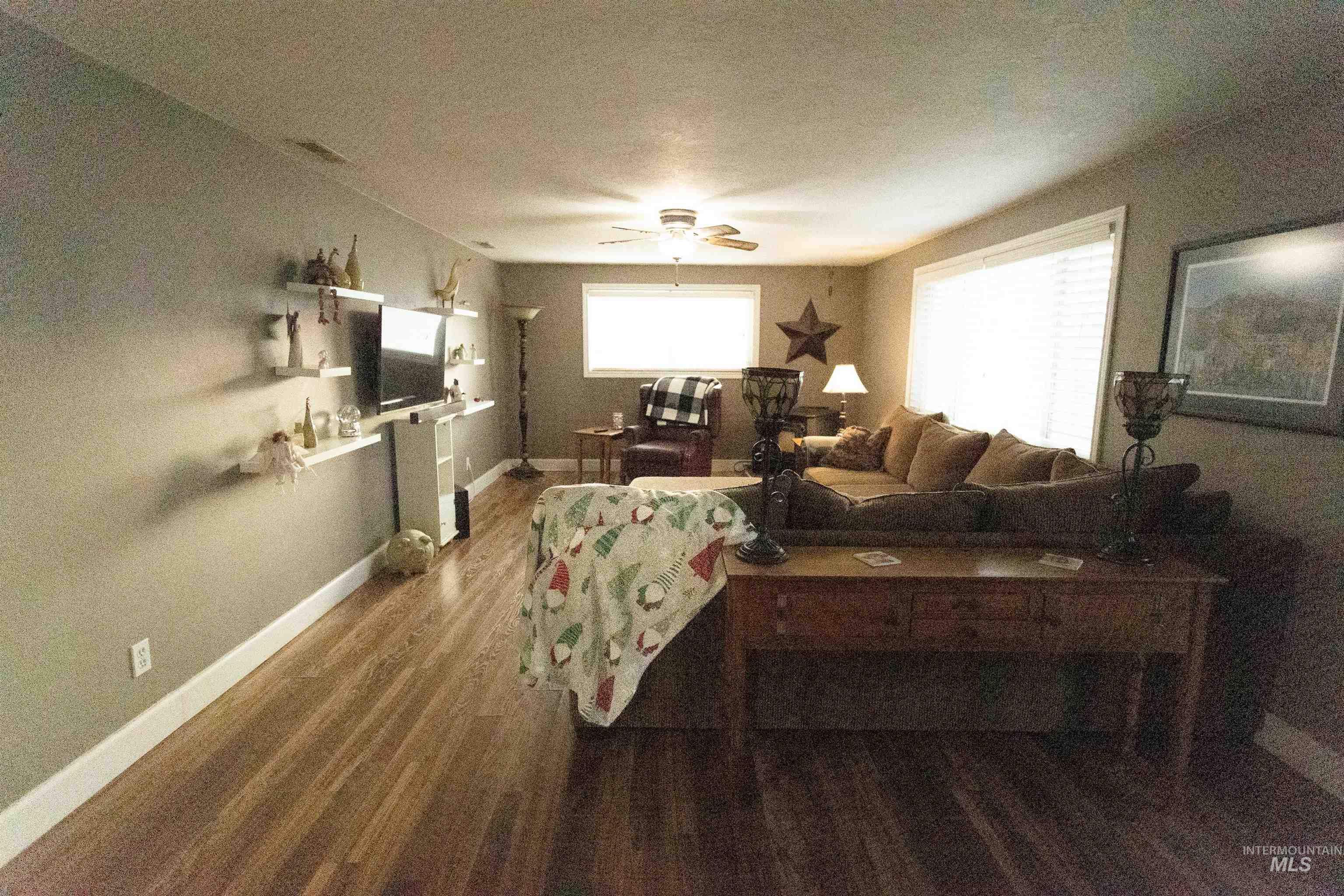 Living room with dark wood-style floors and ceiling fan