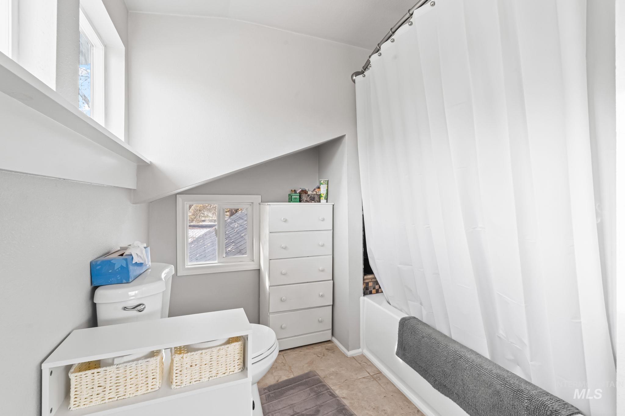 Full bath with shower / bathtub combination with curtain, tile patterned flooring, and vanity