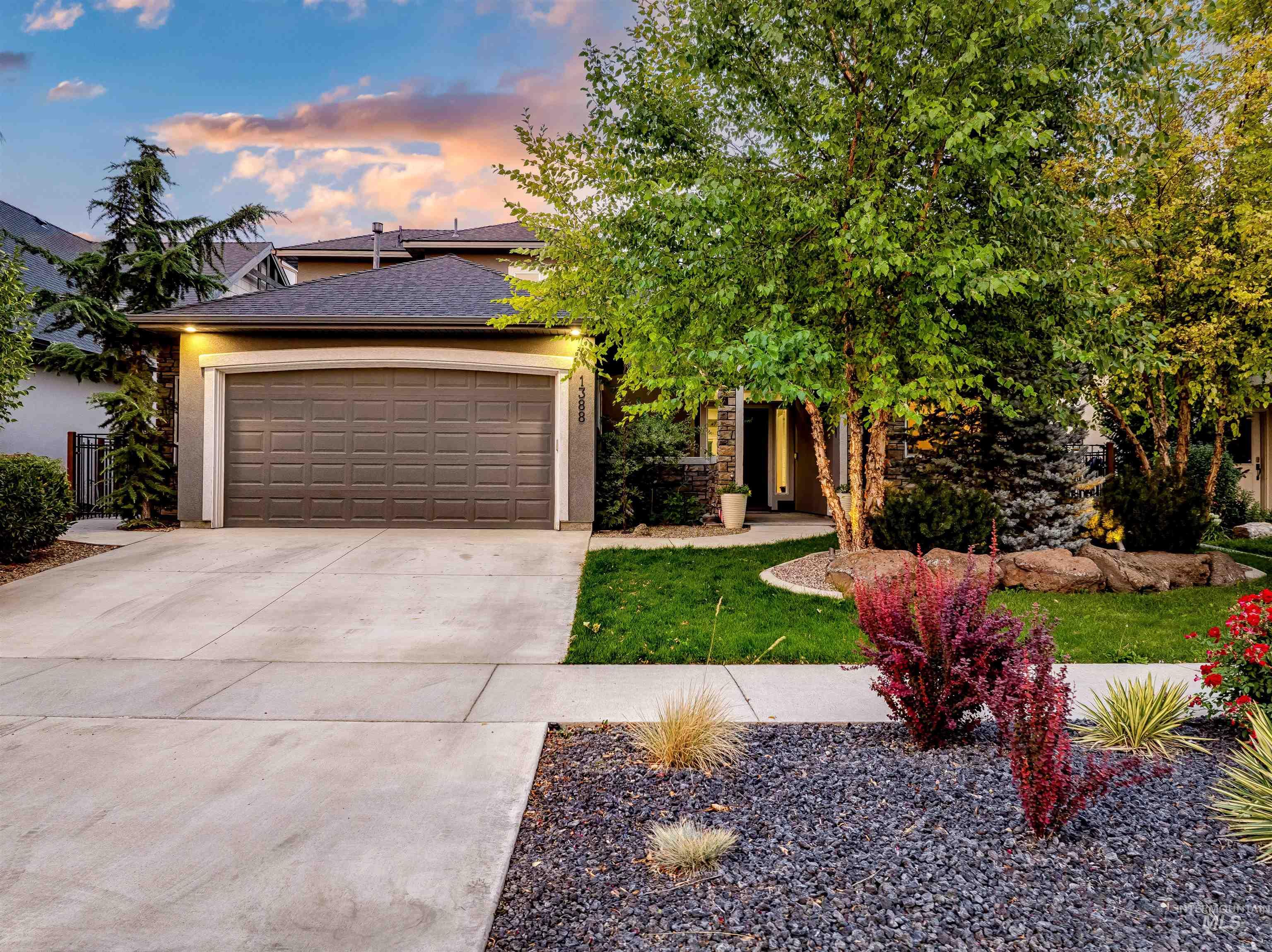 View of front of house with driveway, an attached garage, stucco siding, and a shingled roof
