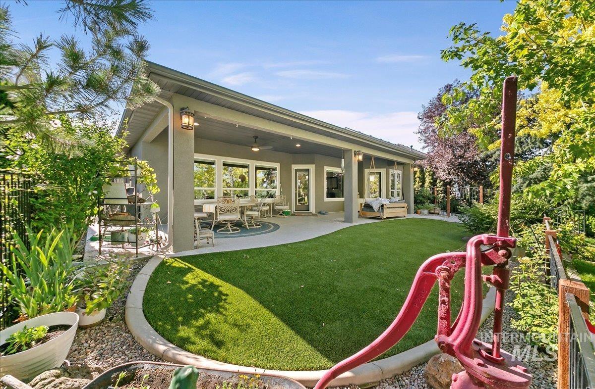 Back of house with stucco siding, ceiling fan, a yard, a patio area, and an outdoor living space
